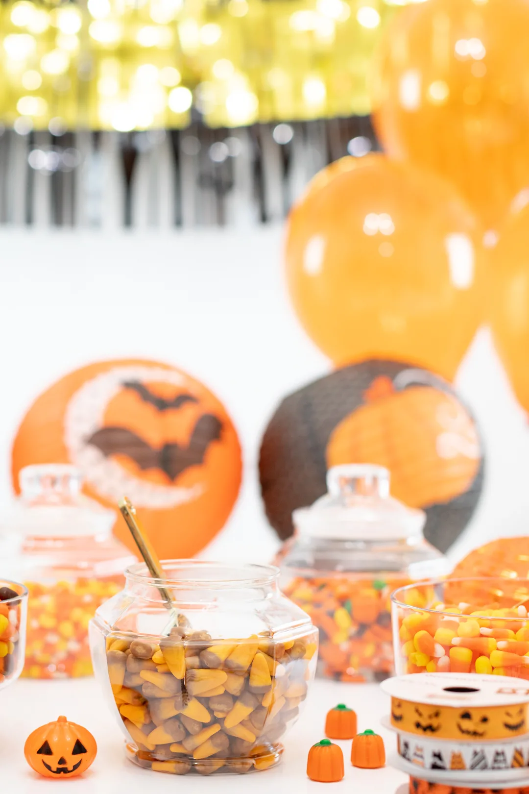 Halloween Treat Bag Station Table with Candy and Black Orange and Gold Halloween Decorations.