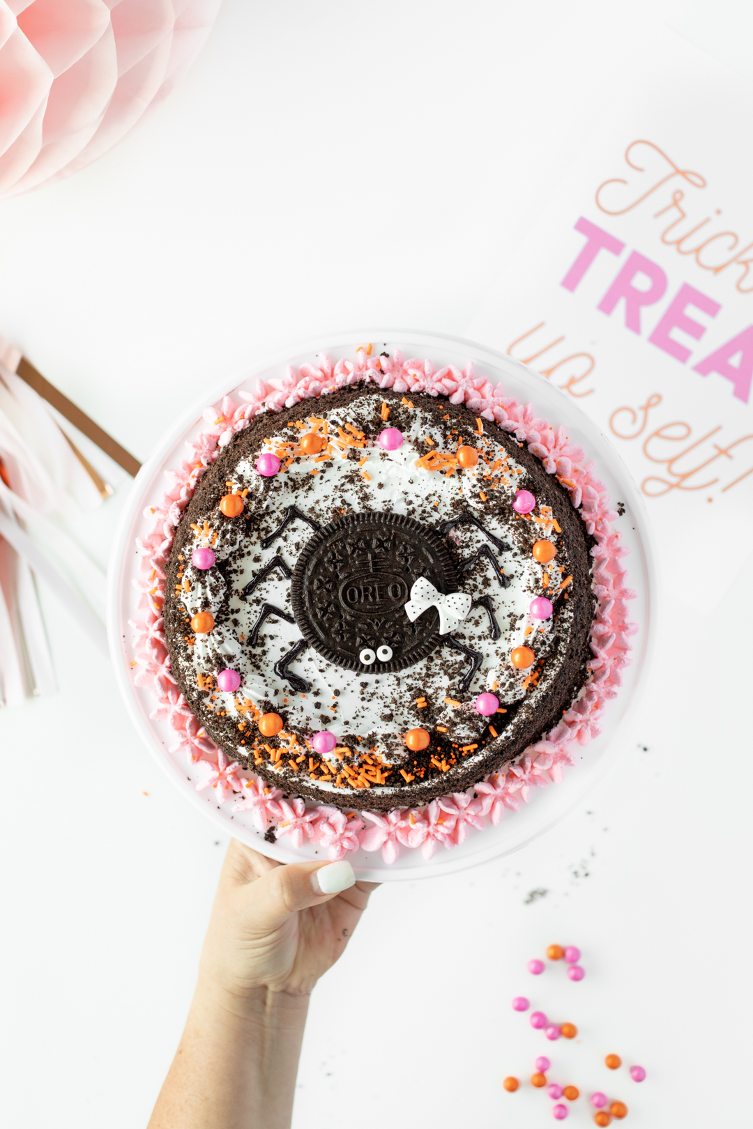 Spider cake with orange and pink decorations and icing.