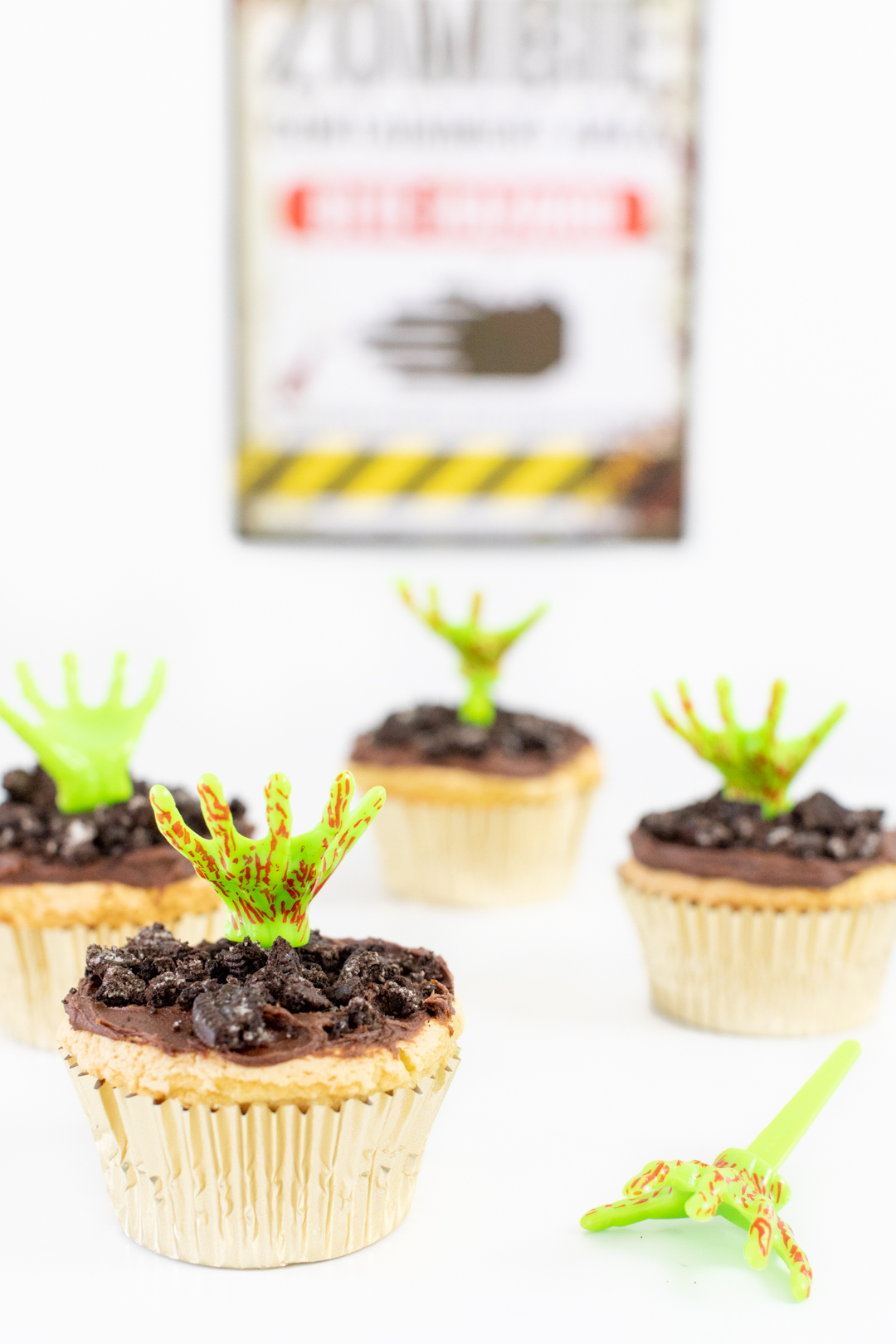 Zombie Cupcakes with Chocolate Crumbly Dirt Topping and Bloody Zombie Hand Coming Out.