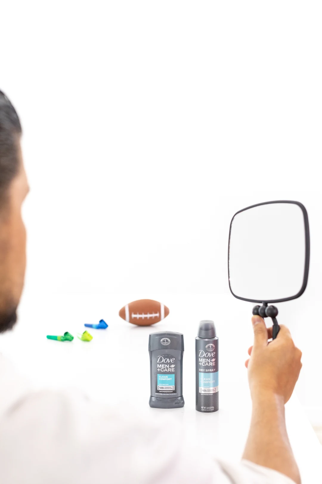 Man grooming with hand-held mirror.