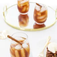 Glass of iced tea with ice and a cinnamon stick served with a slice of pecan pie with ice cream.