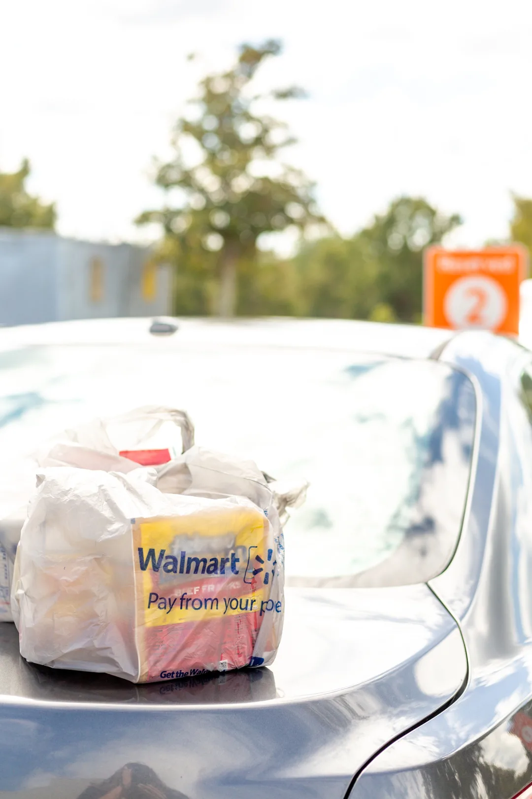 Walmart Online Grocery Pickup bags on top of a car