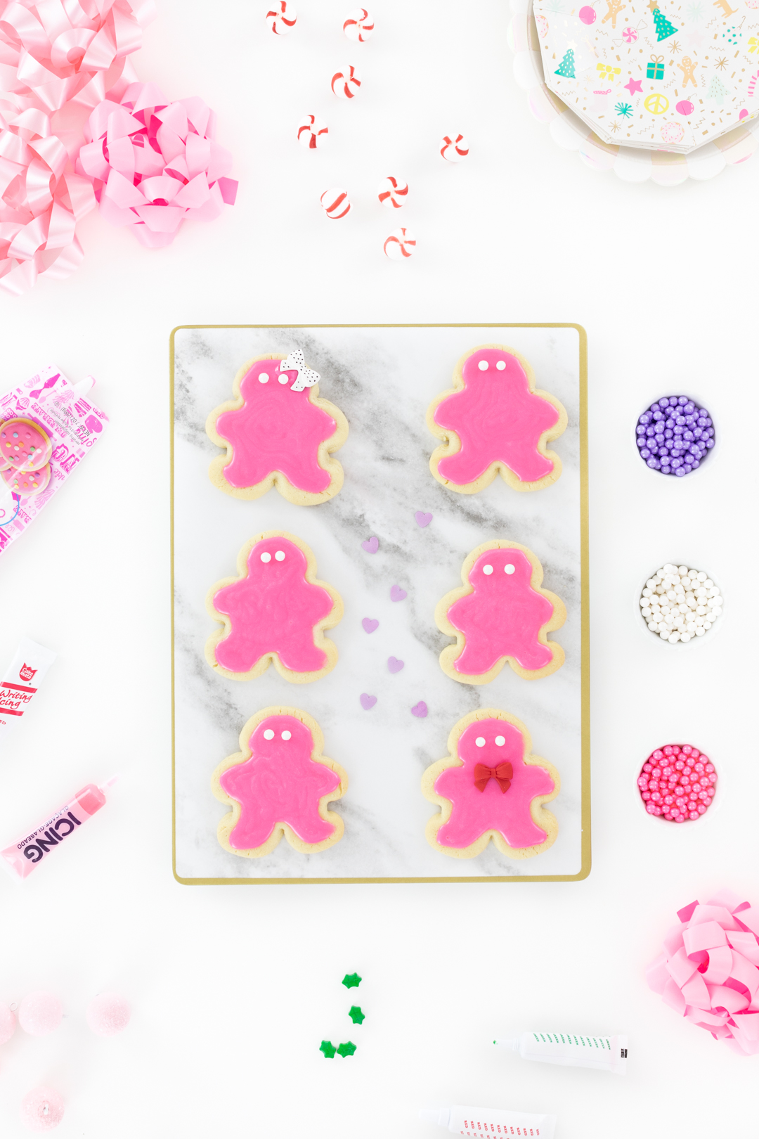 decorating pink gingerbread shaped sugar cookies