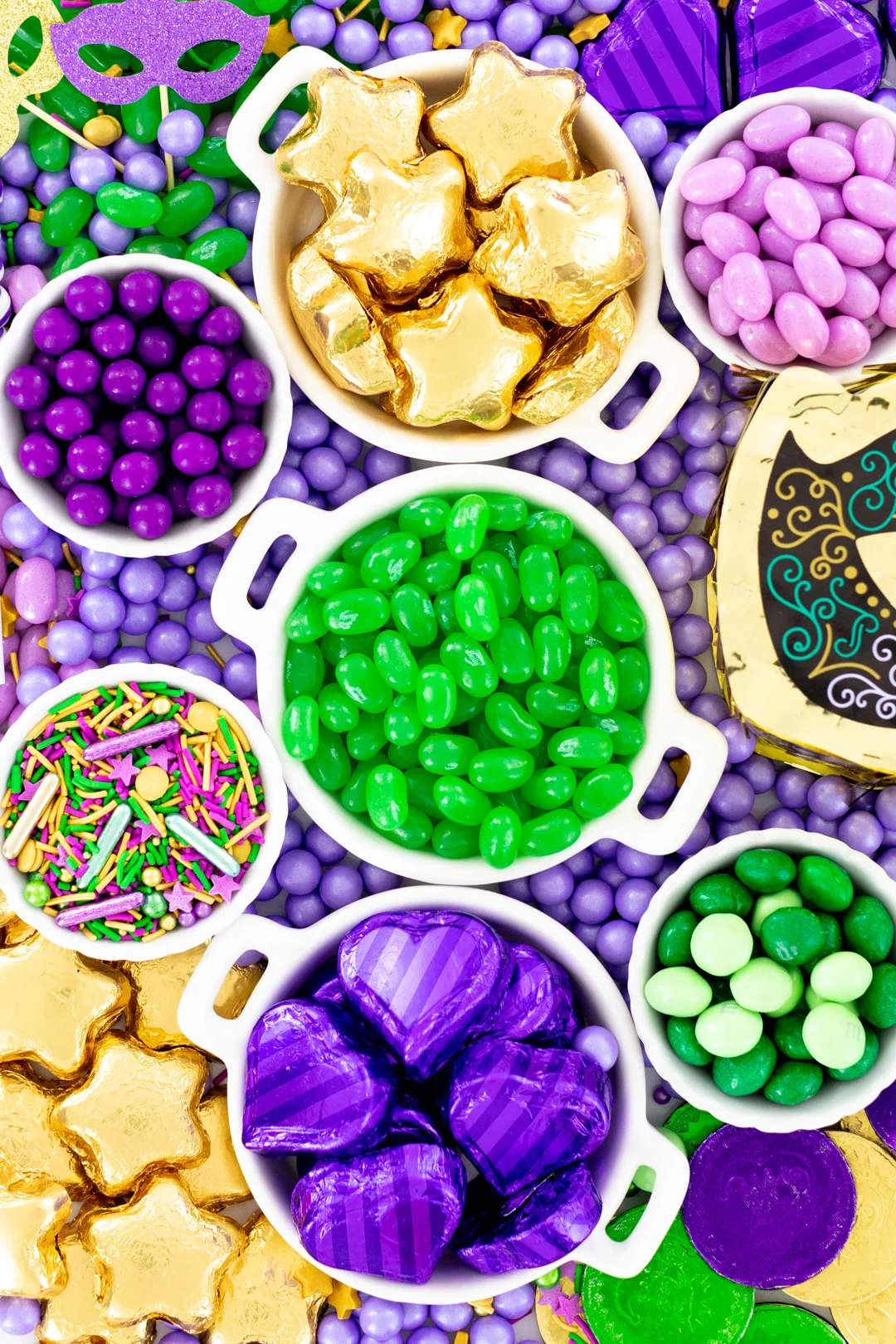 candy tray up close with gold foil star shaped chocolates, green jelly beans, mini M&Ms.