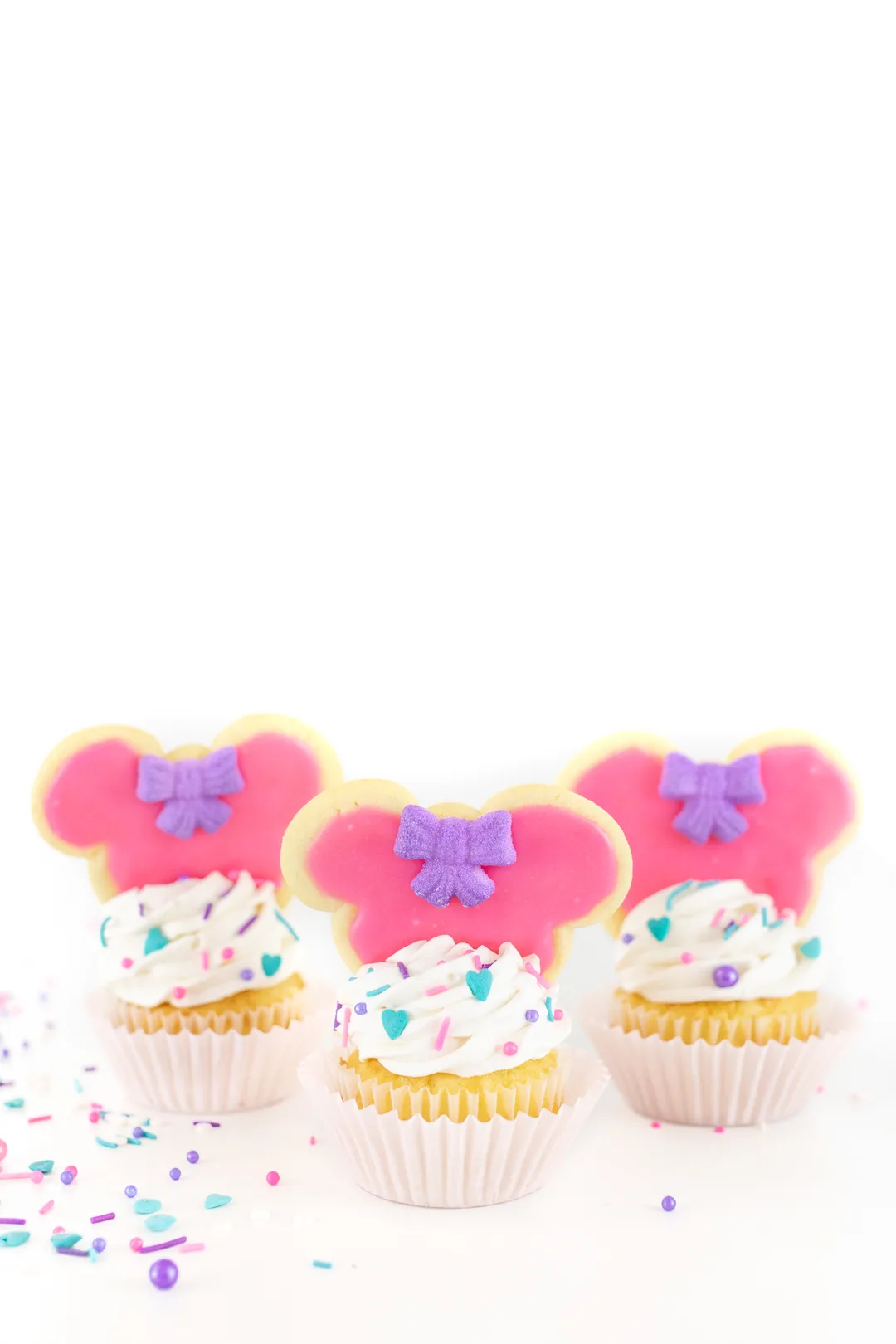 Adorable minnie mouse cookies placed on top of cupcakes