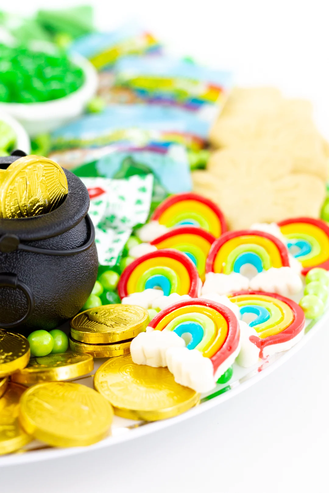 rainbow gummy candies and gold coins on a tray