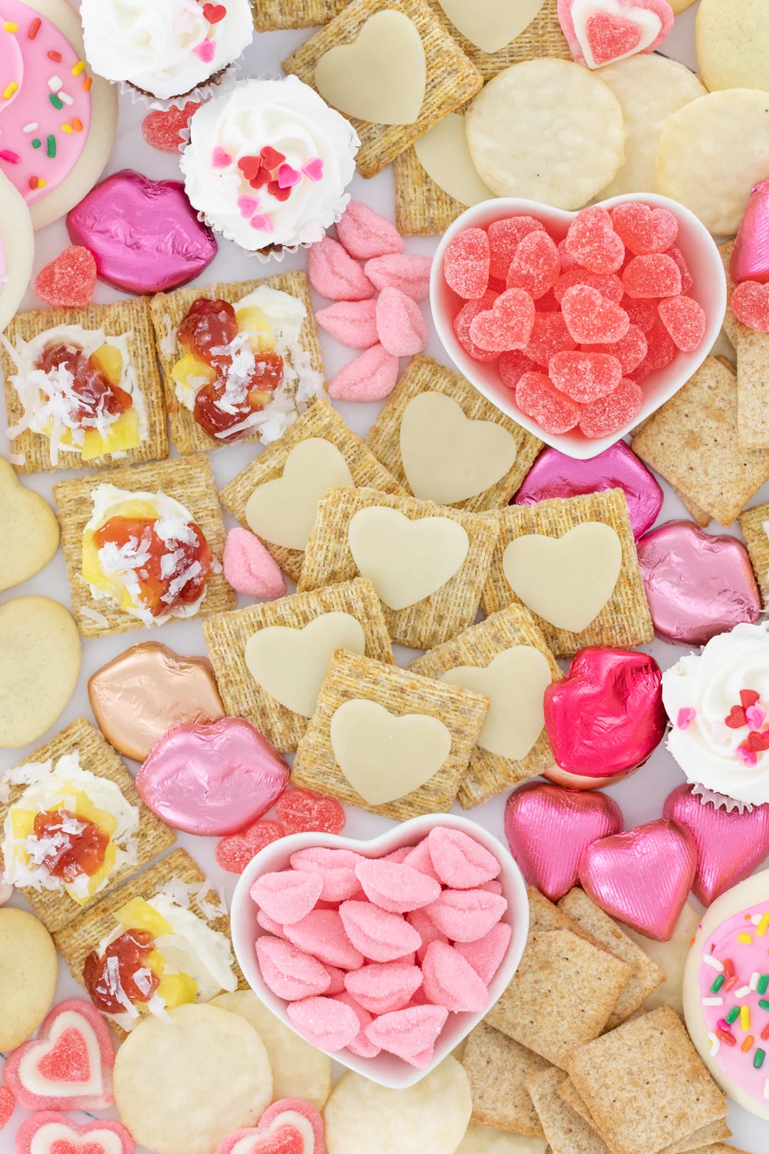 pretty snack board with heart shaped cookies and candies