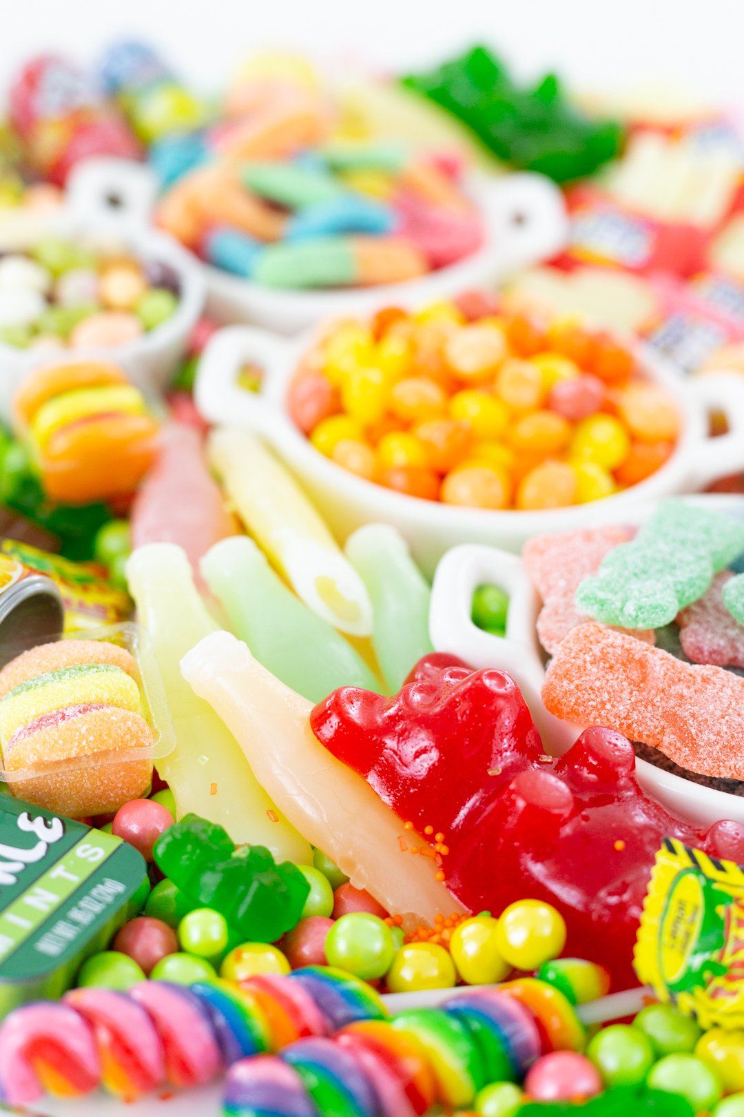 Funny tray of candies with giant gummy bear, colorful lollipops, soda candies.