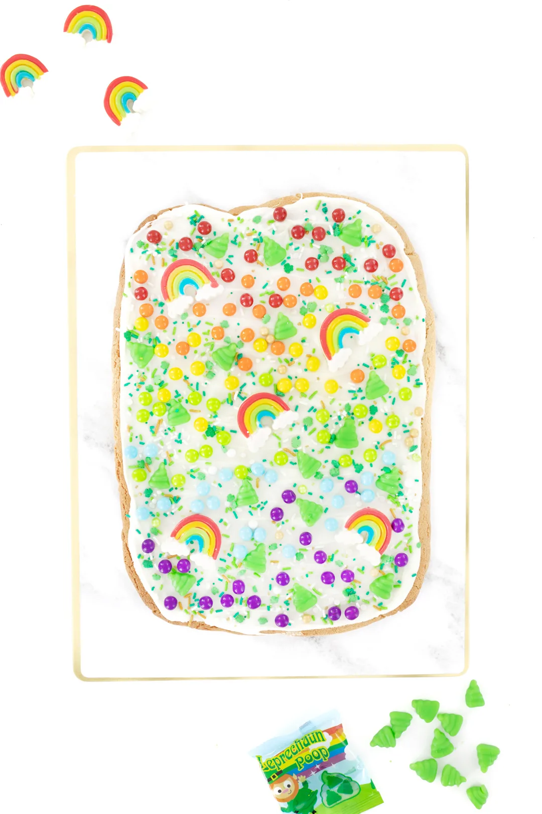 pretty rainbow cookie bark with rainbow candies, rainbow gummies and Leprechaun poop candies.