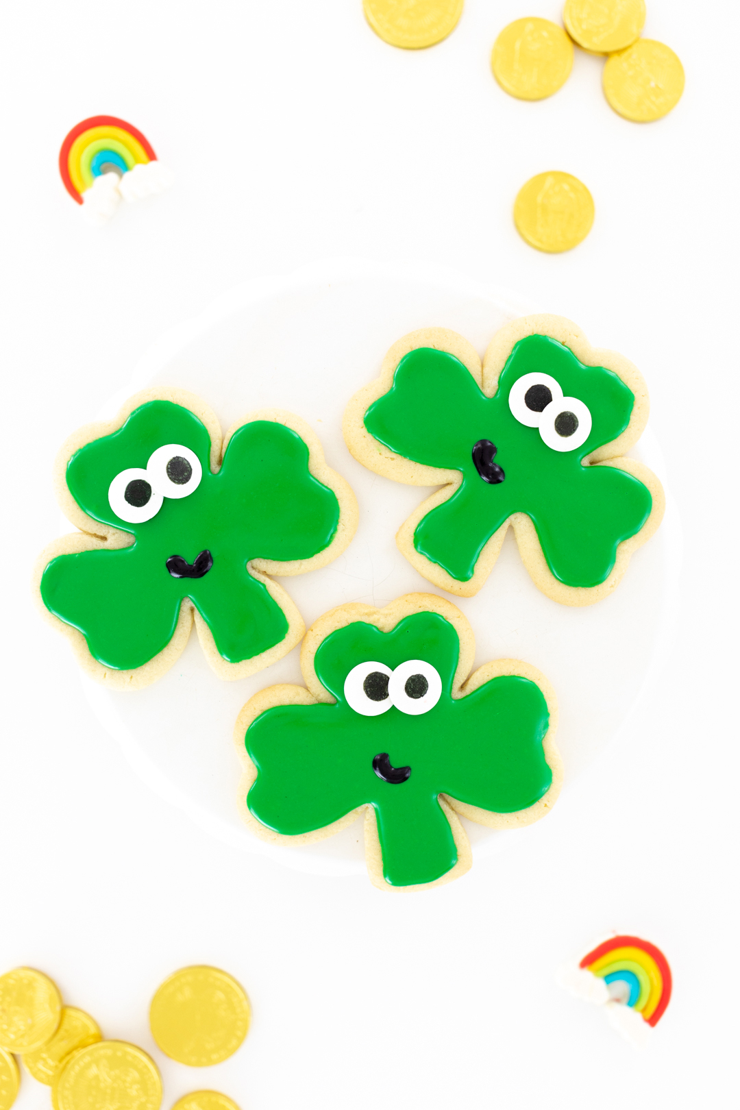 shamrock cookies with big eyes and tiny smiles for st. patrick's day