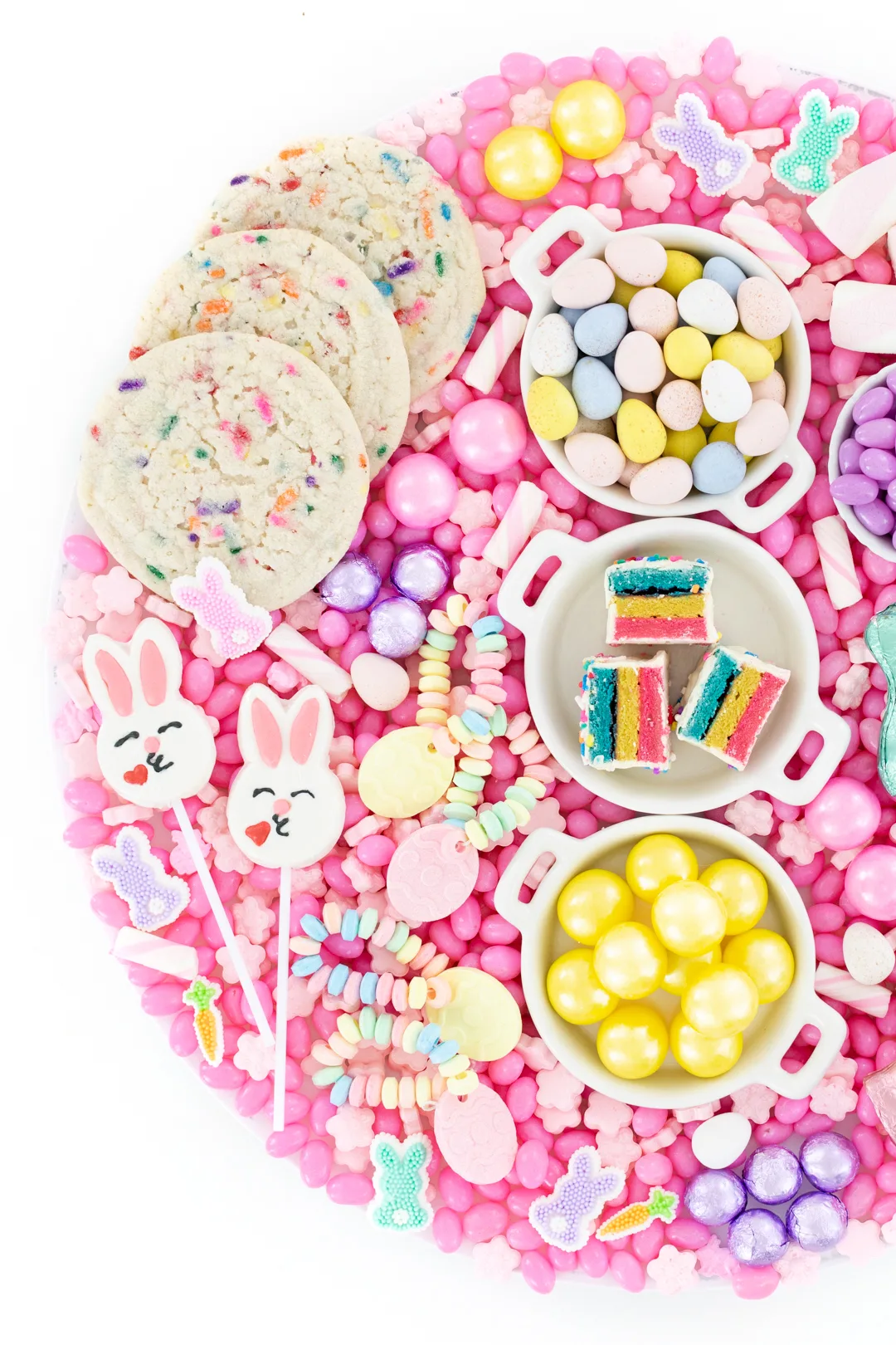 pretty easter candy tray with desserts and candies that are pastel colored