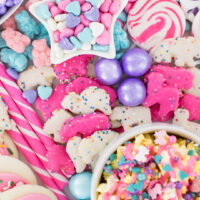 Tray filled with pastel candies, gumballs, cookies, pastel popcorn.