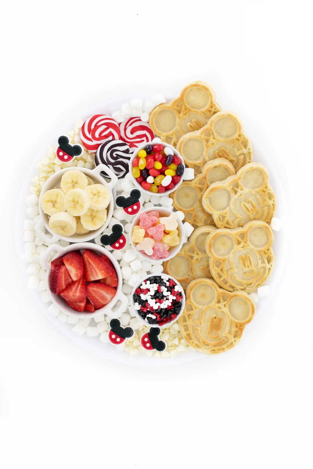 cute disney mickey mouse charcuterie board with waffles and waffle toppings including bananas and strawberries