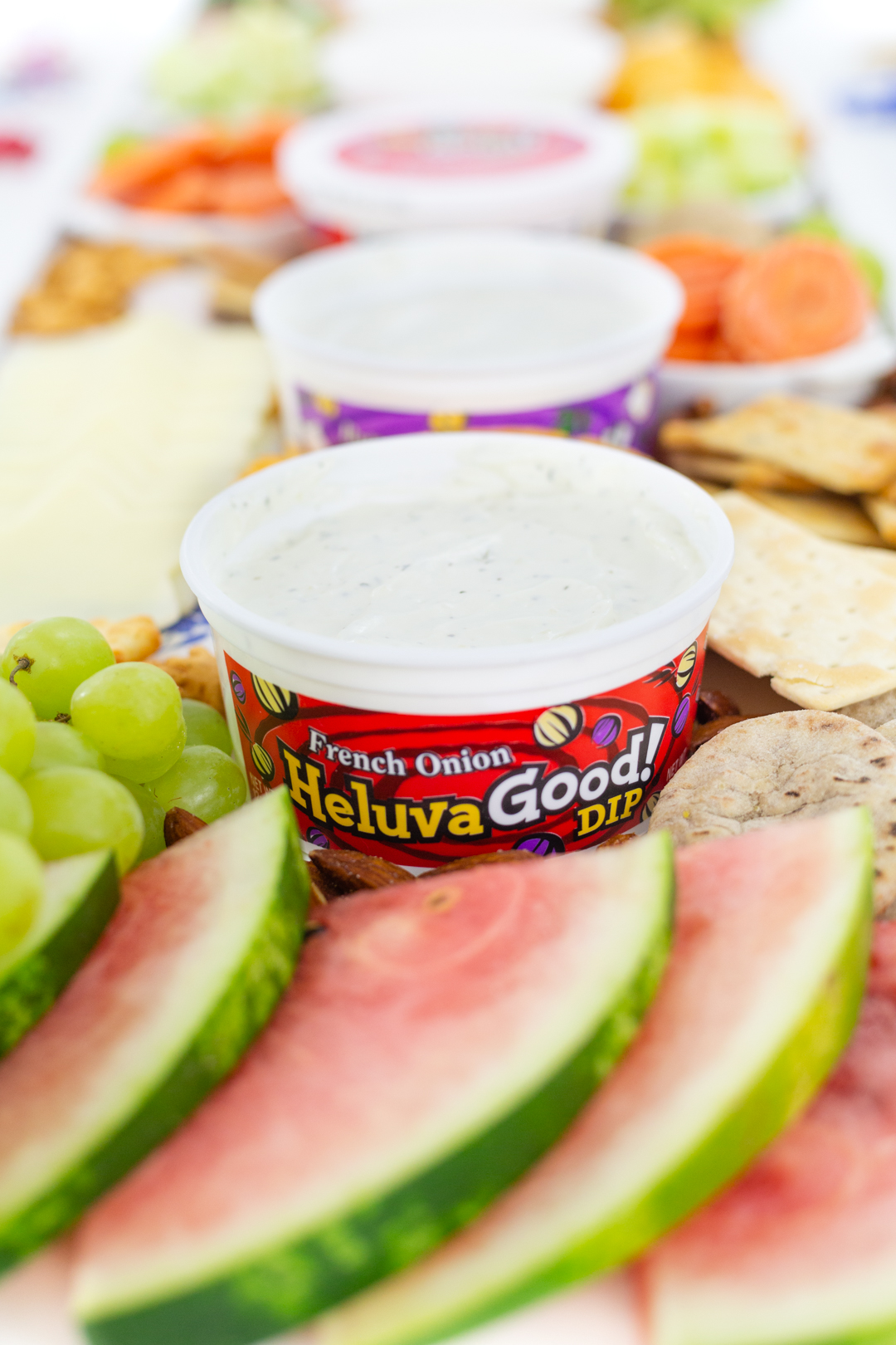 tray of fruits with dip, cheese and crackers