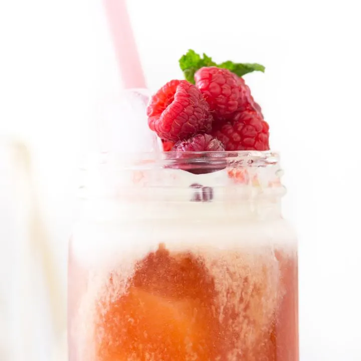 creamy raspberry tea topped with fresh fruit and herbs.