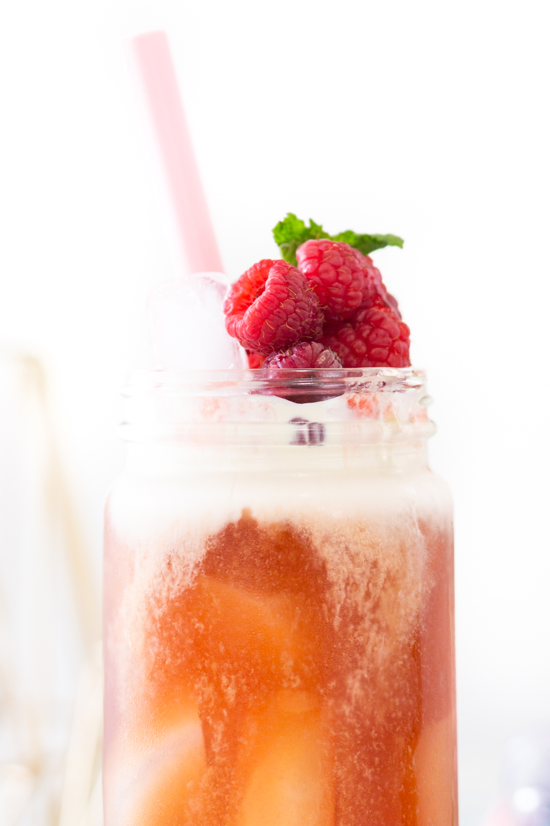 creamy raspberry tea topped with fresh fruit and herbs.