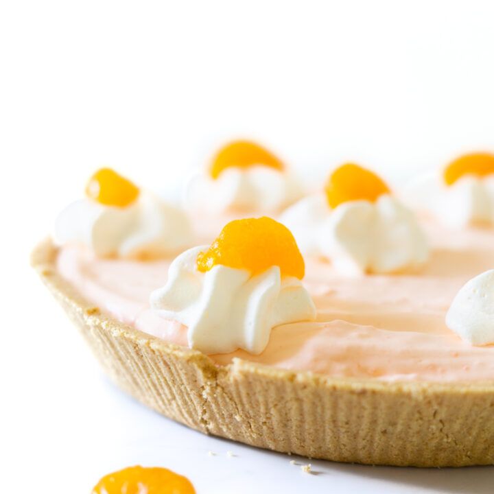 mandarin orange pie close up with whipped cream and mandarin orange garnish