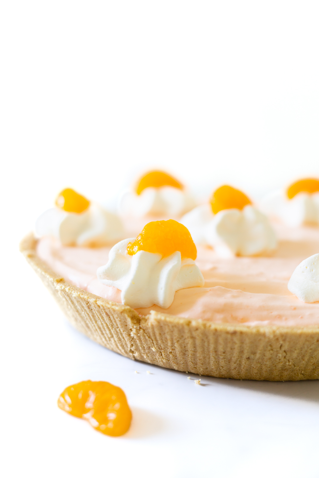 mandarin orange pie close up with whipped cream and mandarin orange garnish