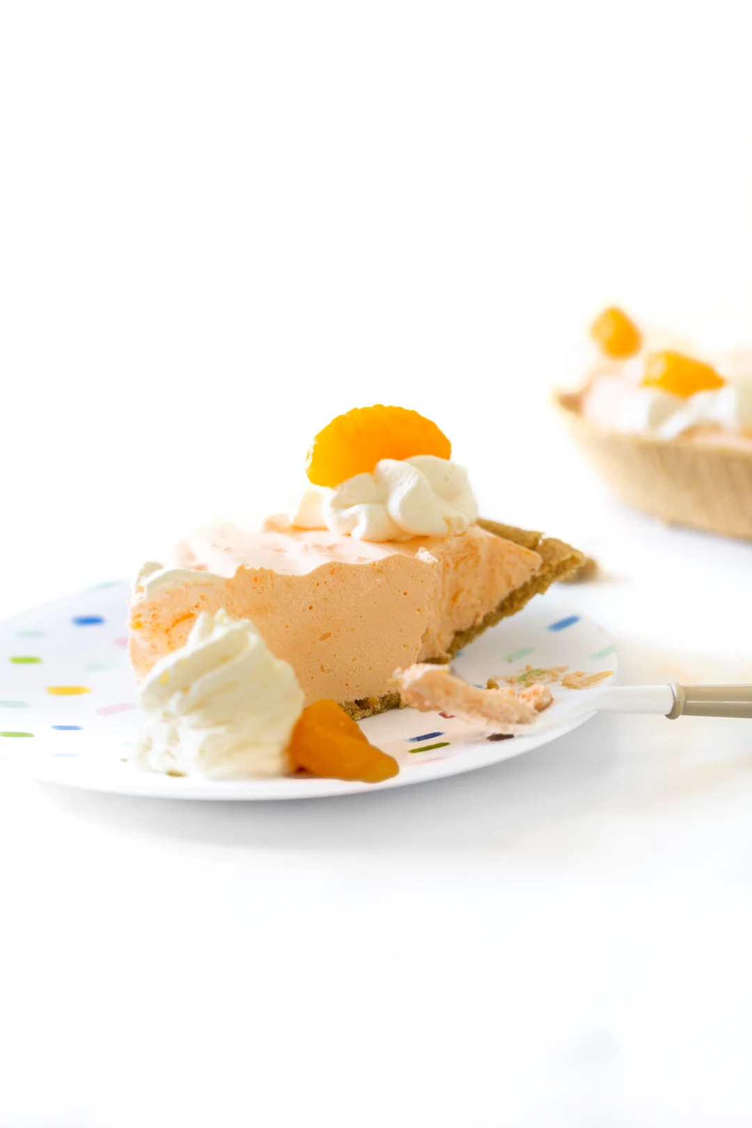 rich summer pie, slice shown on a plate with whipped cream and mandarin orange