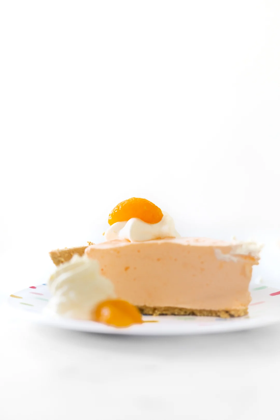 slice of pretty orange pie and topped with fruit garnish