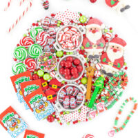 fun christmas candy board with red and green candies. flat lay style photo with candies displayed all over the table.