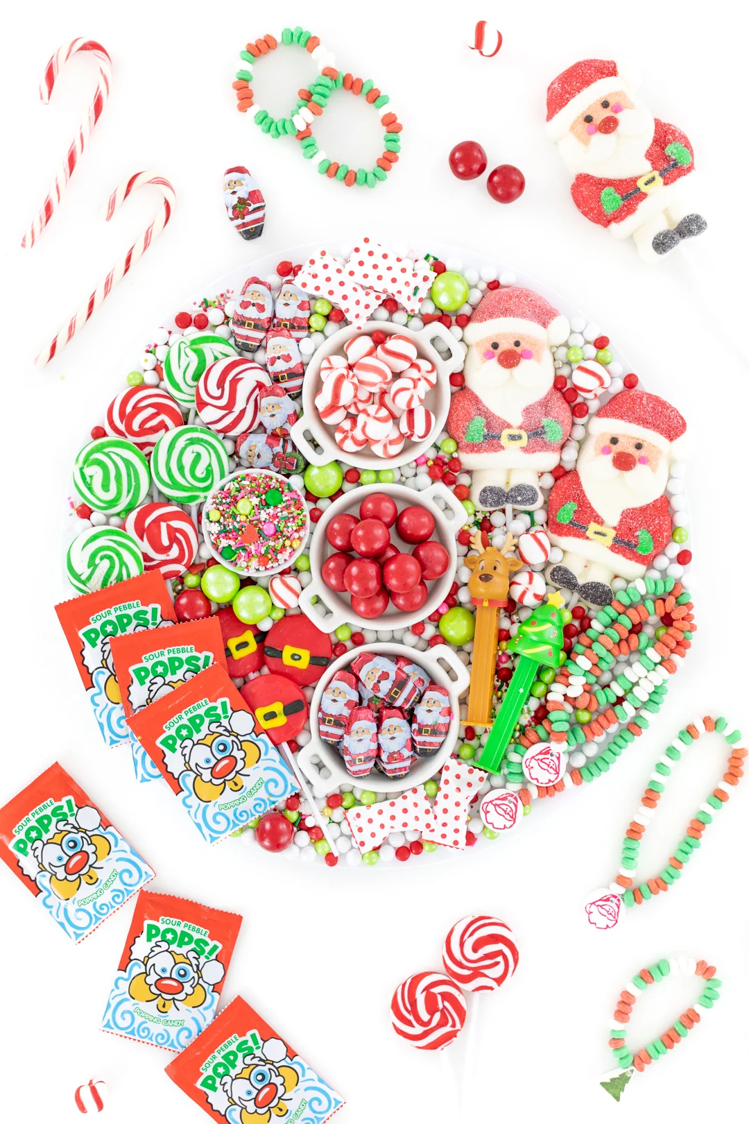 fun christmas candy board with red and green candies. flat lay style photo with candies displayed all over the table.