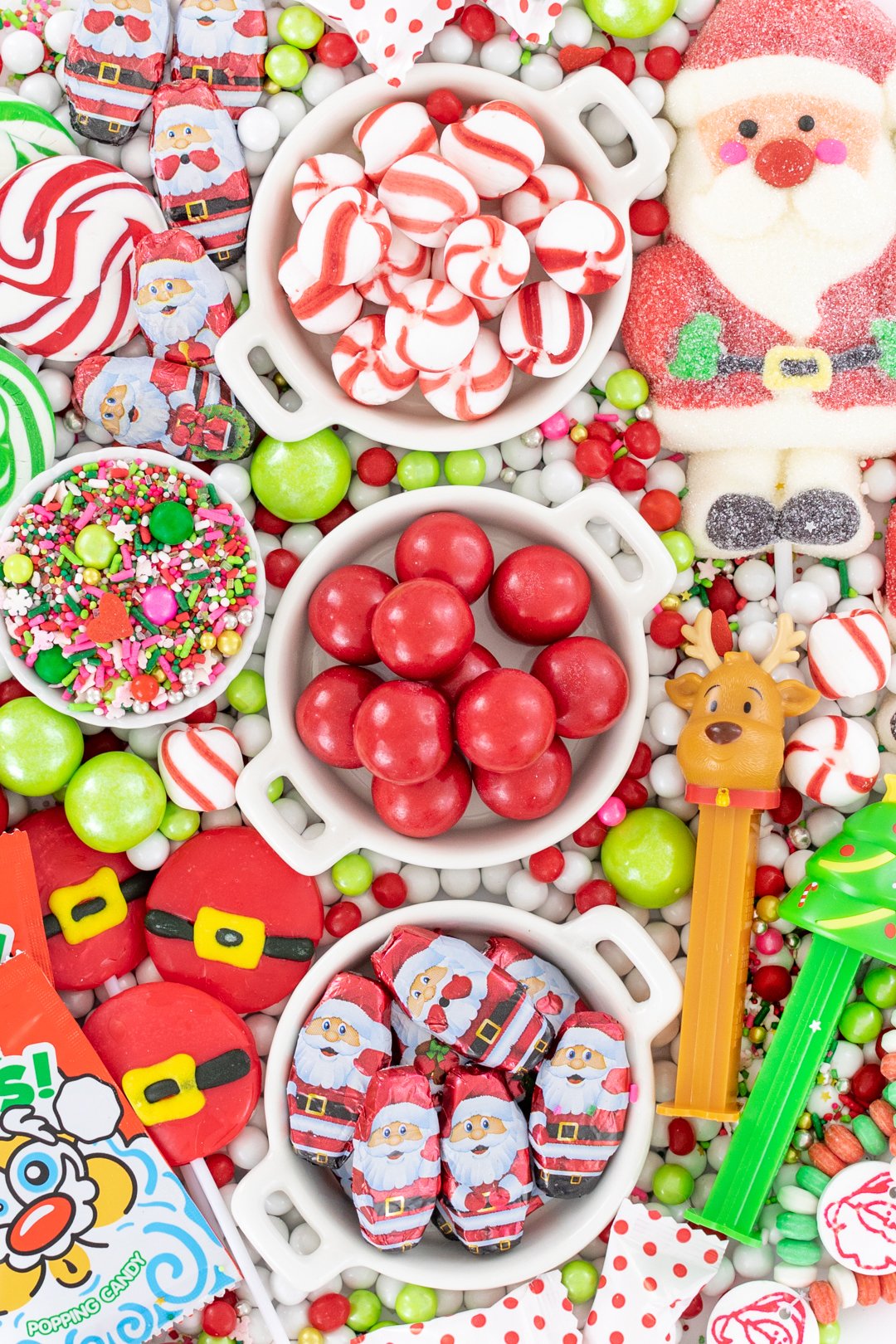 up close of christmas candy charcuterie board with santa belt lollipops and peppermints