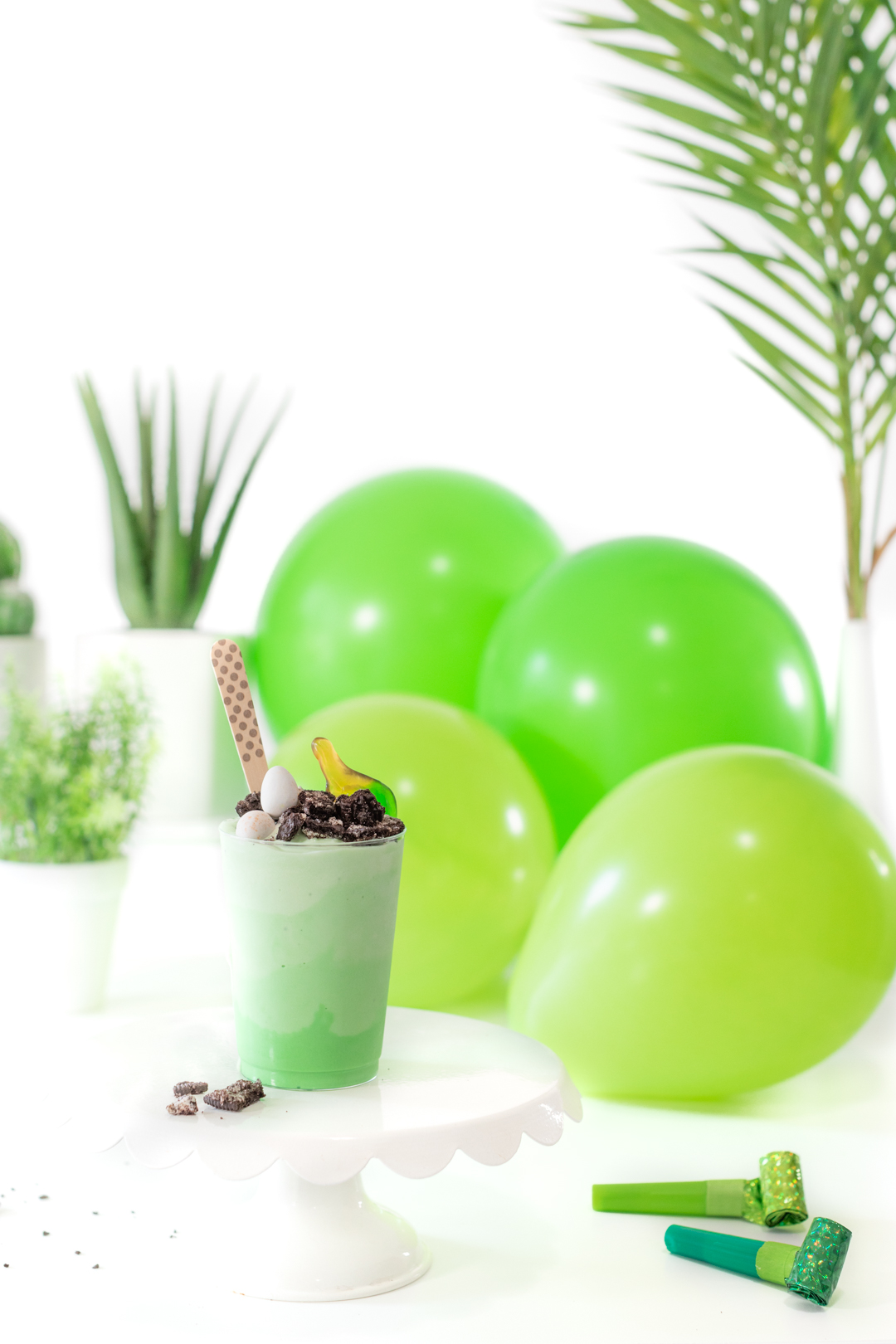 dino party with shades of green balloons and sundaes with layers of ice cream