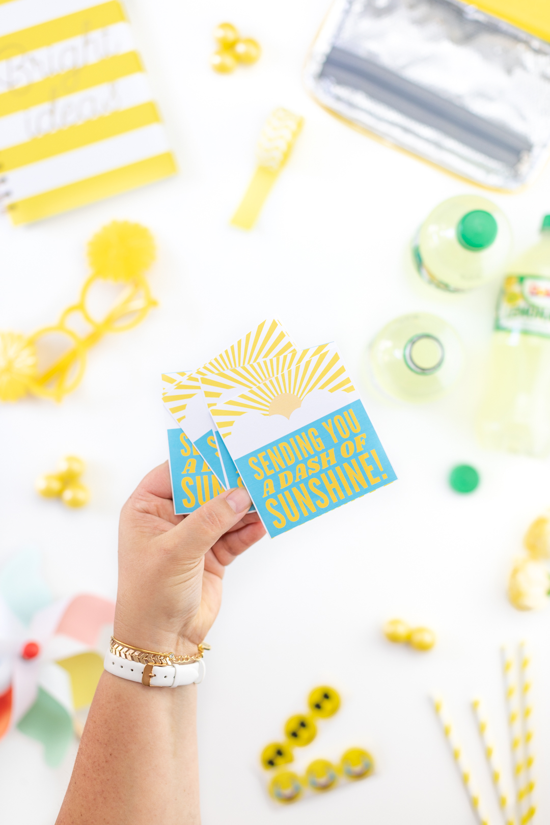 holding printed gift tags that read sending you a dash of sunshine