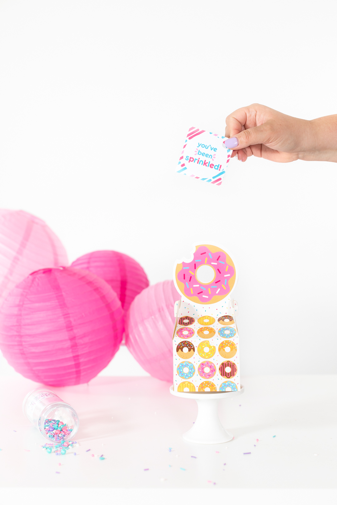 adding cute sprinkle gift tag to donut gift box