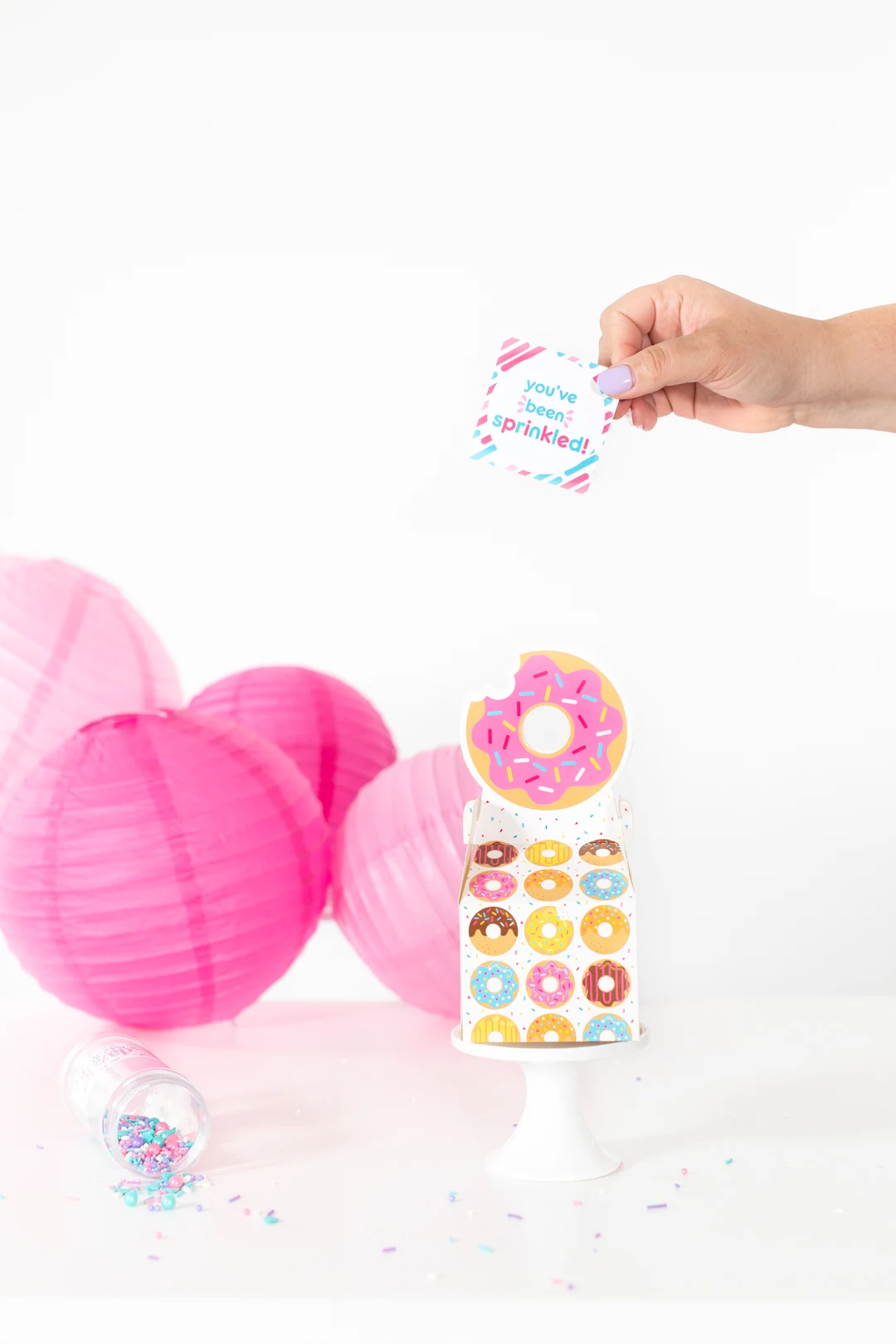 adding cute sprinkle gift tag to donut gift box