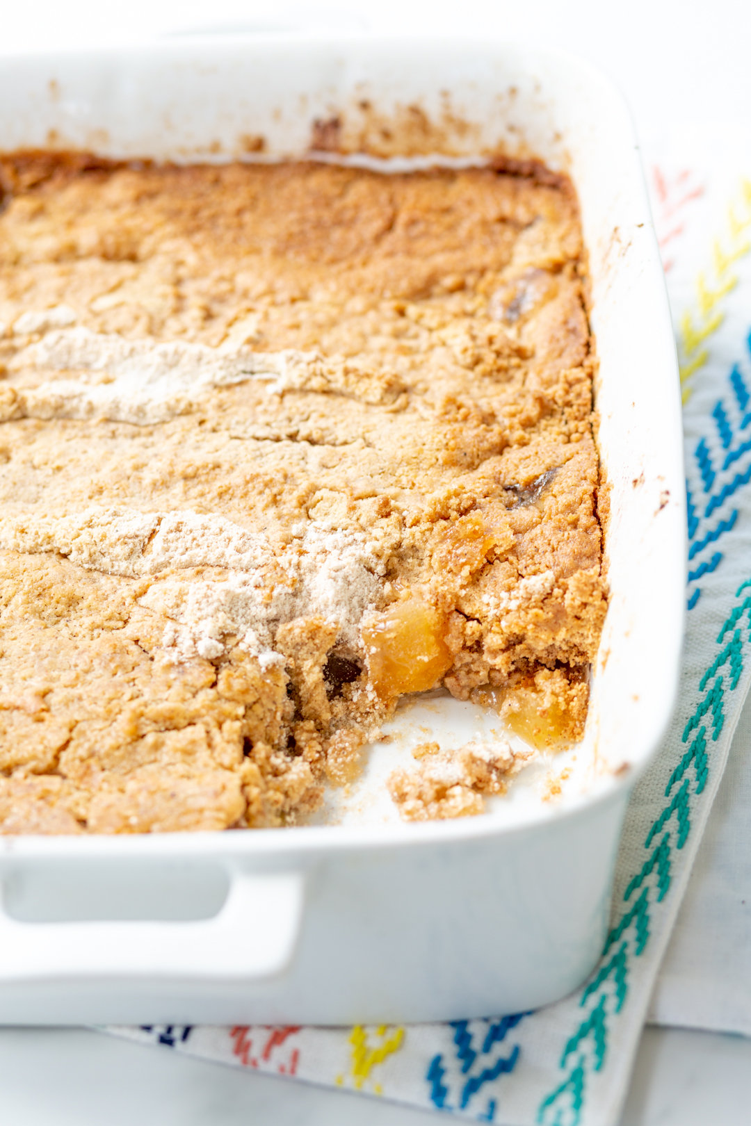 baking dish with apple dump cake, serving scooped out