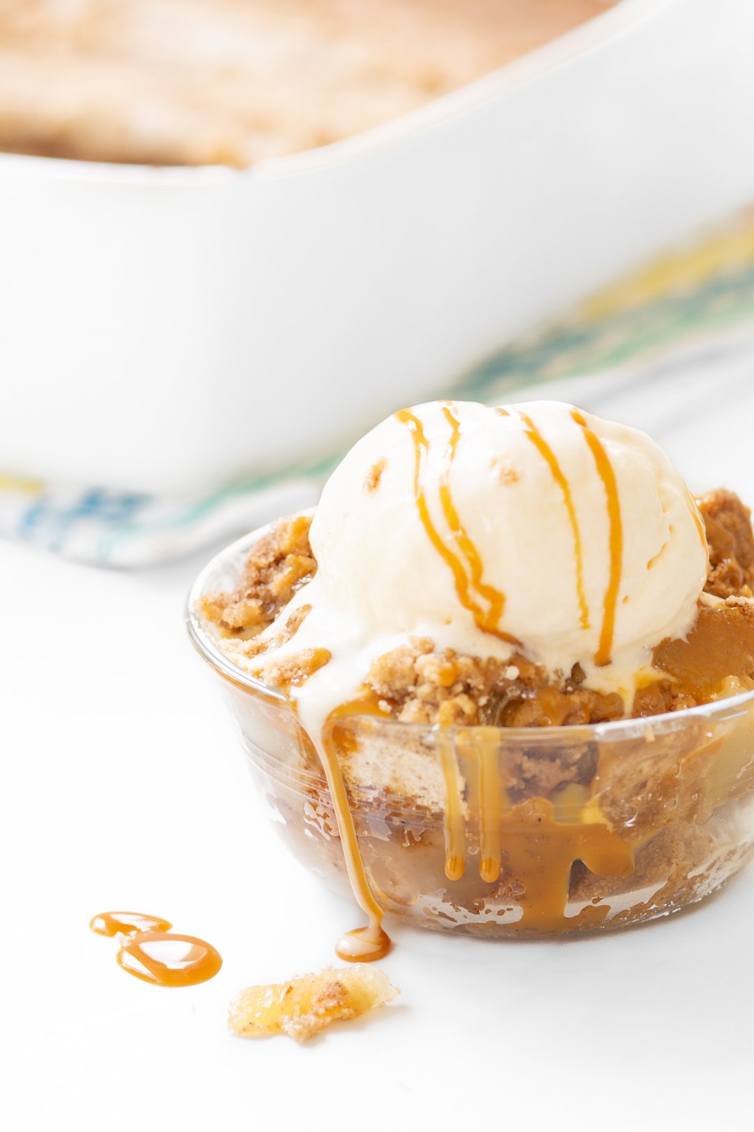 dump cake in a dish with ice cream and caramel on top