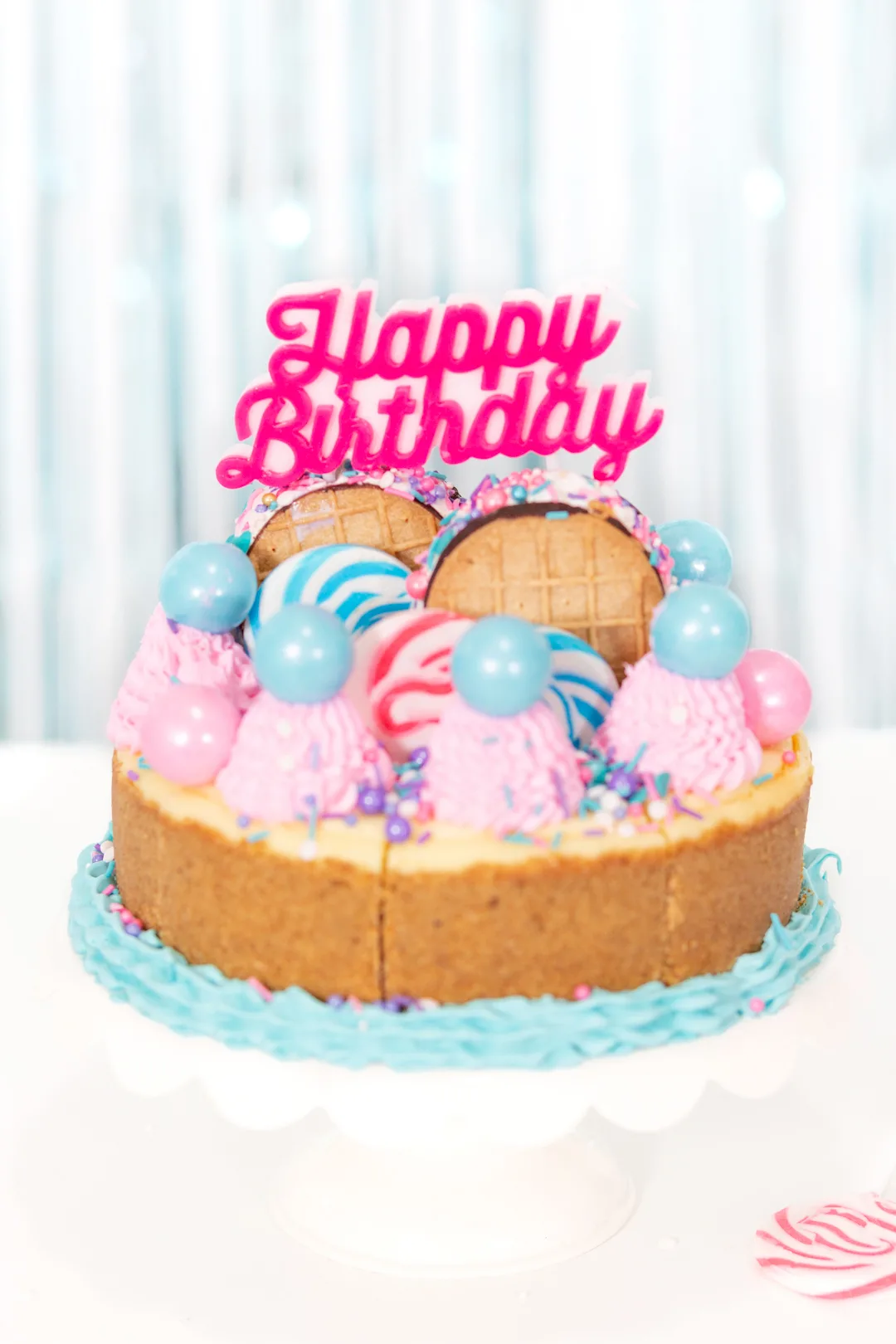 birthday cheesecake up close with pink and blue cake decorations