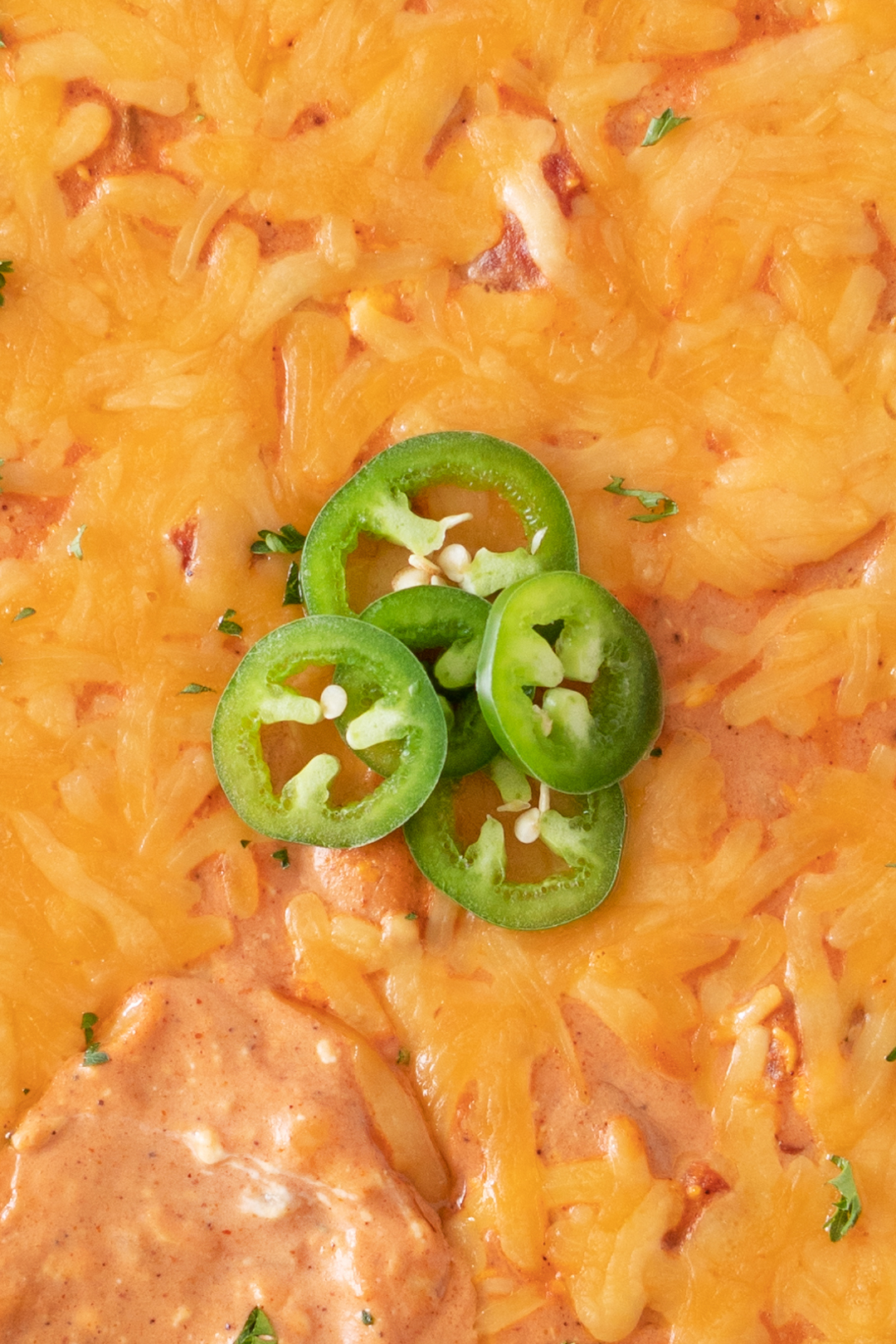 cheese dip up close topped with sliced jalapenos