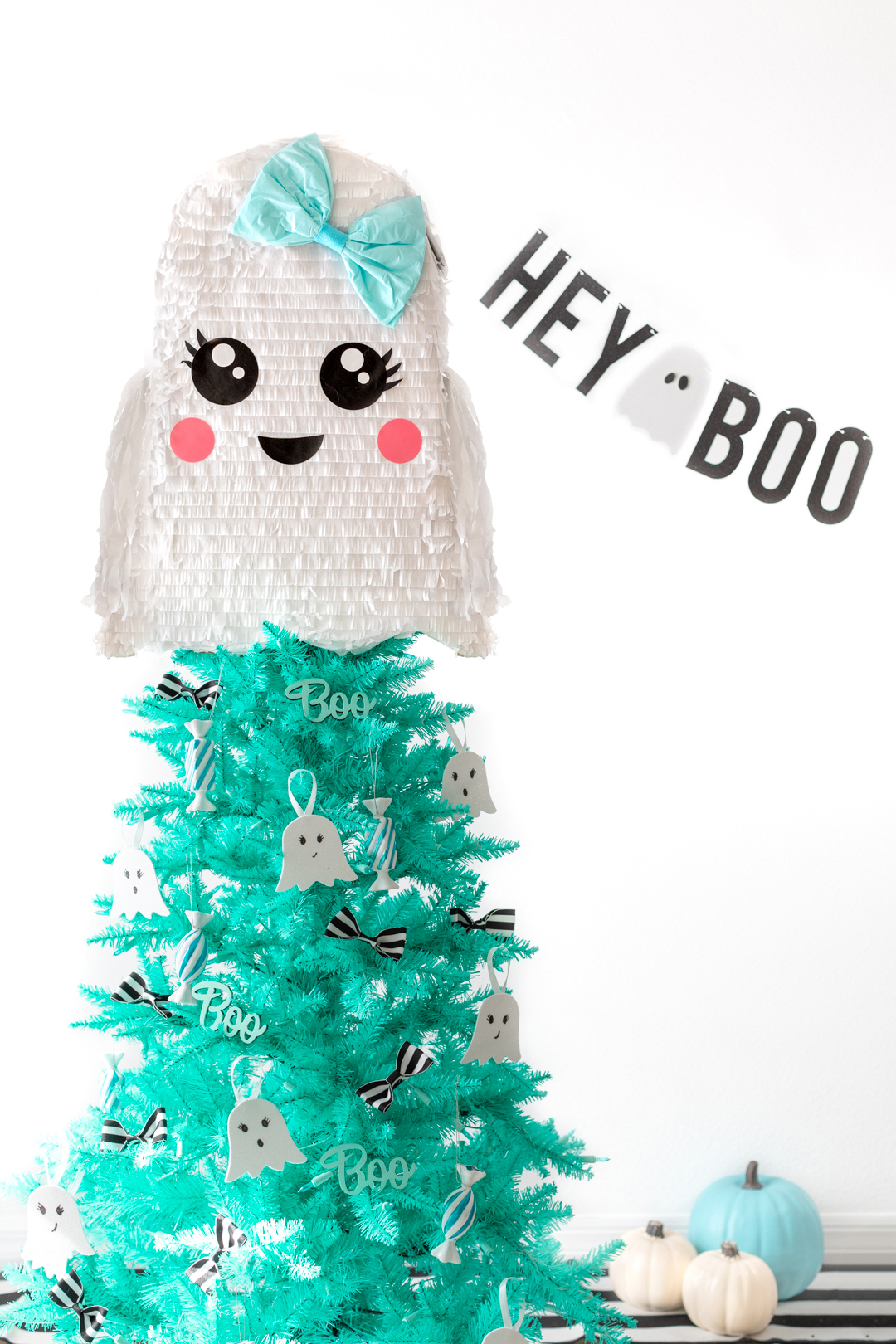 ghost themed halloween christmas tree with banner that says hey boo.