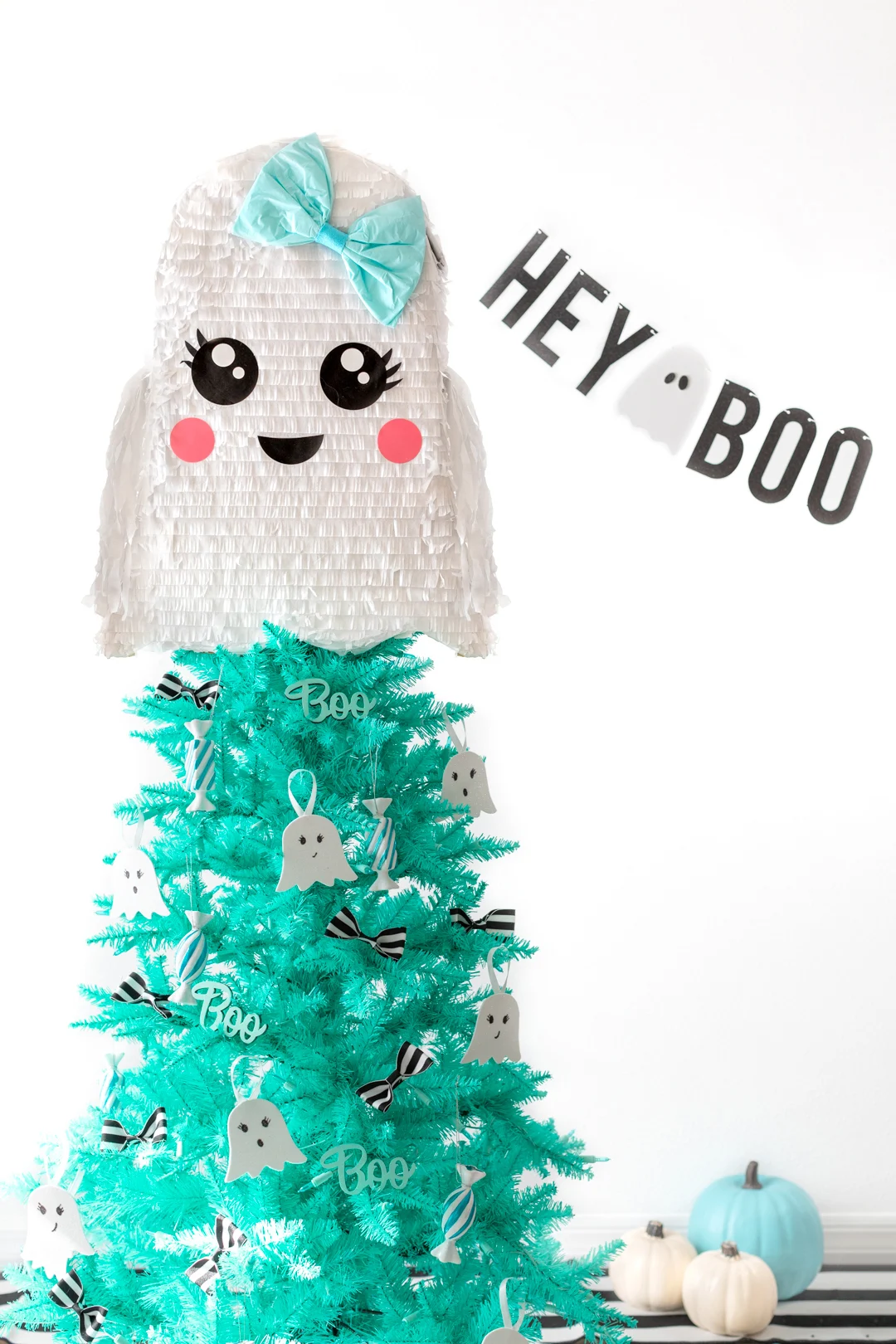 ghost themed halloween christmas tree with banner that says hey boo.