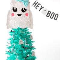 ghost themed halloween christmas tree with banner that says hey boo.