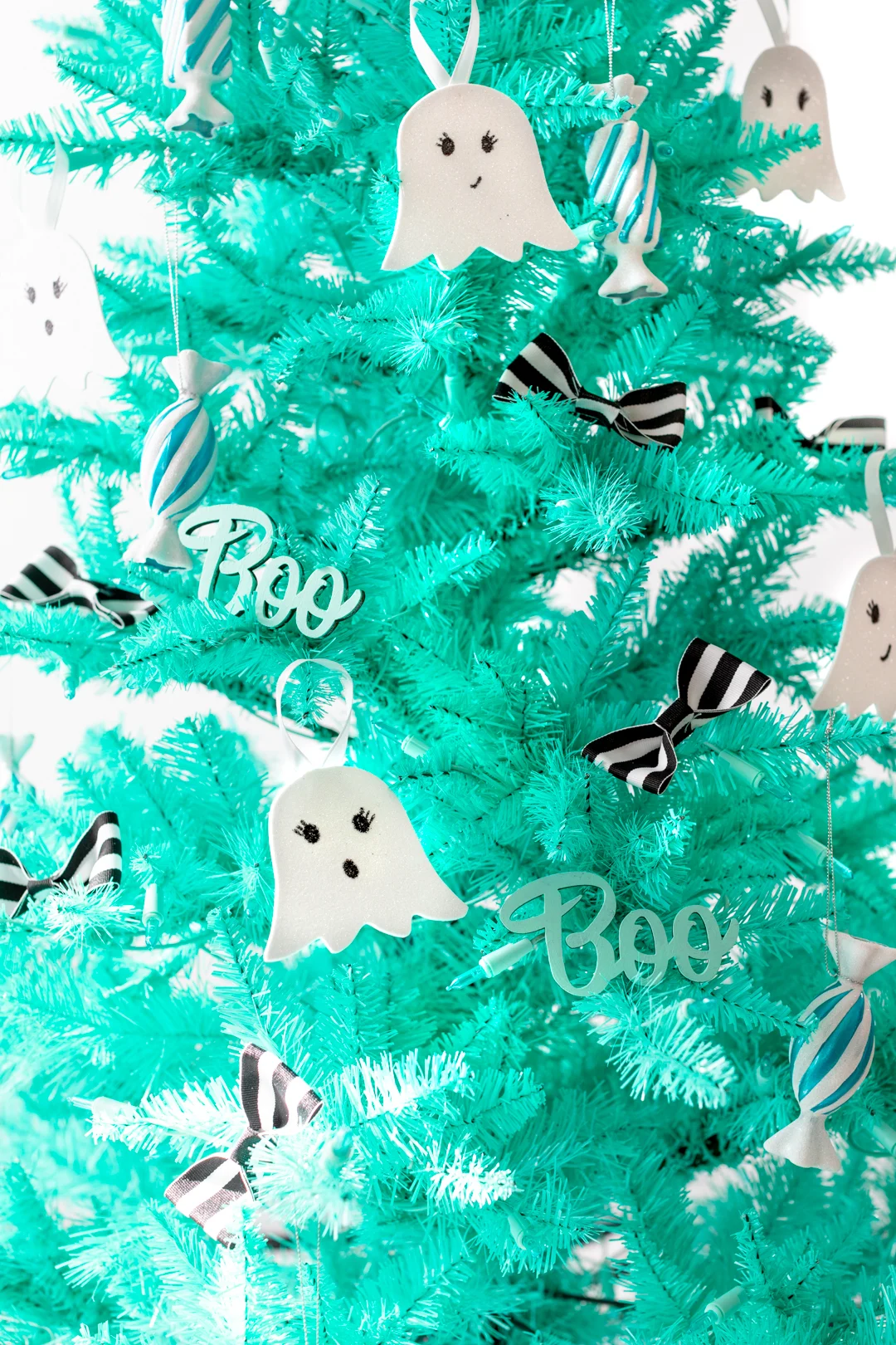 close up of a halloween christmas tree with black and white striped bow decorations, ghost ornaments and candy ornaments