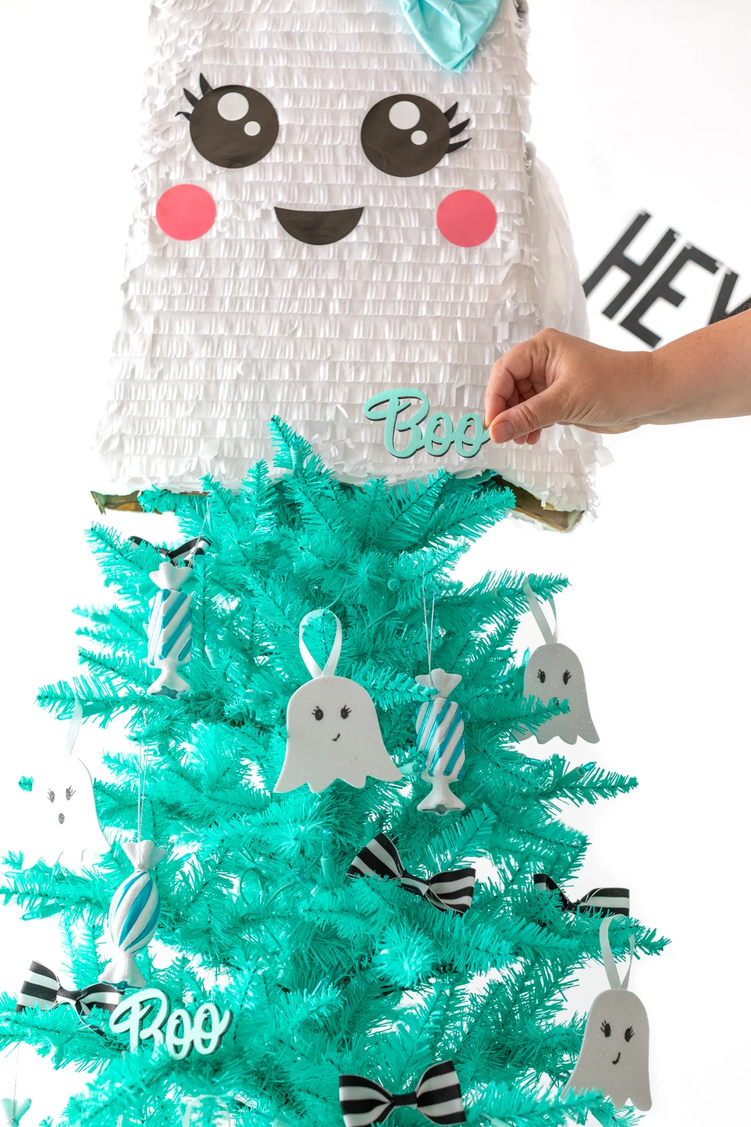 cute hand-painted boo sign being used as a christmas tree decoration for halloween