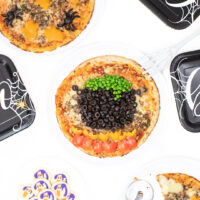 witch cauldron pizza and ghost cookies set out on a table for serving