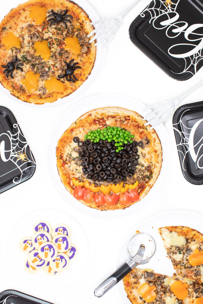 witch cauldron pizza and ghost cookies set out on a table for serving