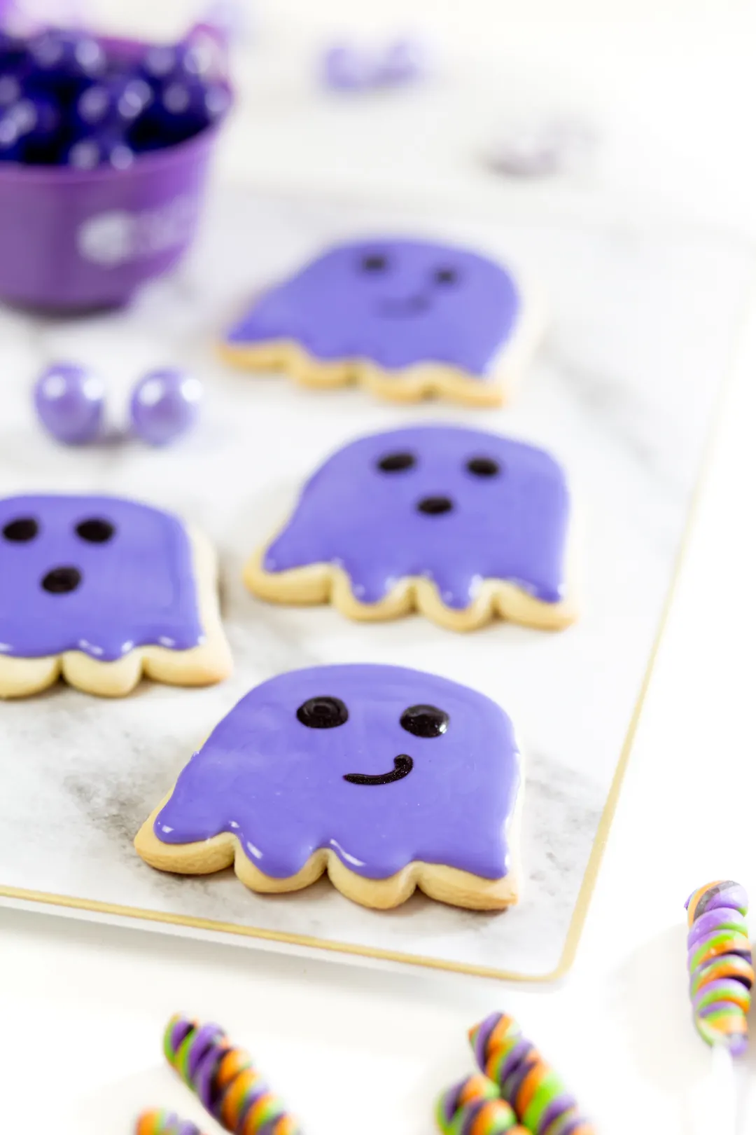 purple ghost cookies on a tray, freshy iced with purple cookie icing