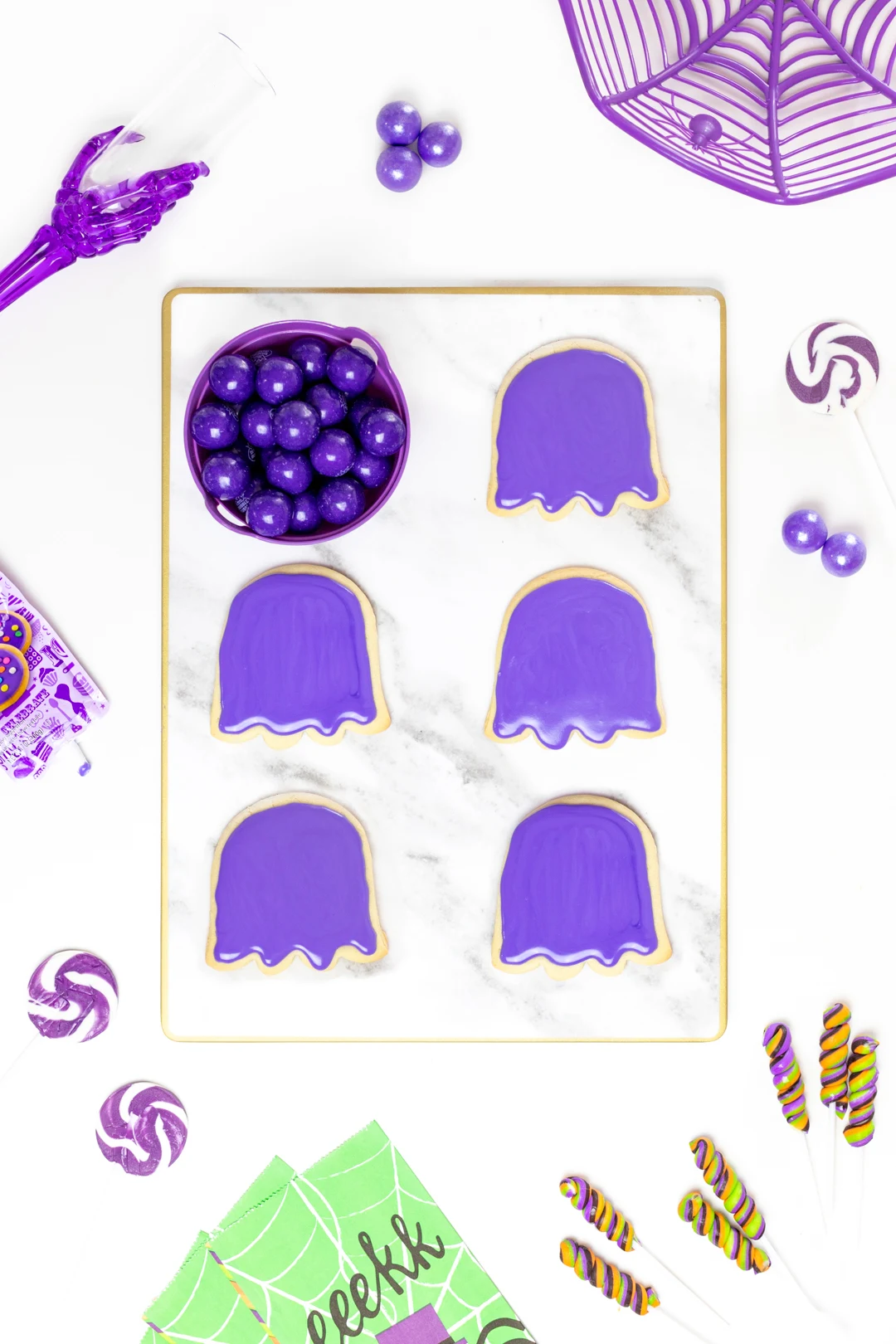 purple iced halloween cookies on a tray