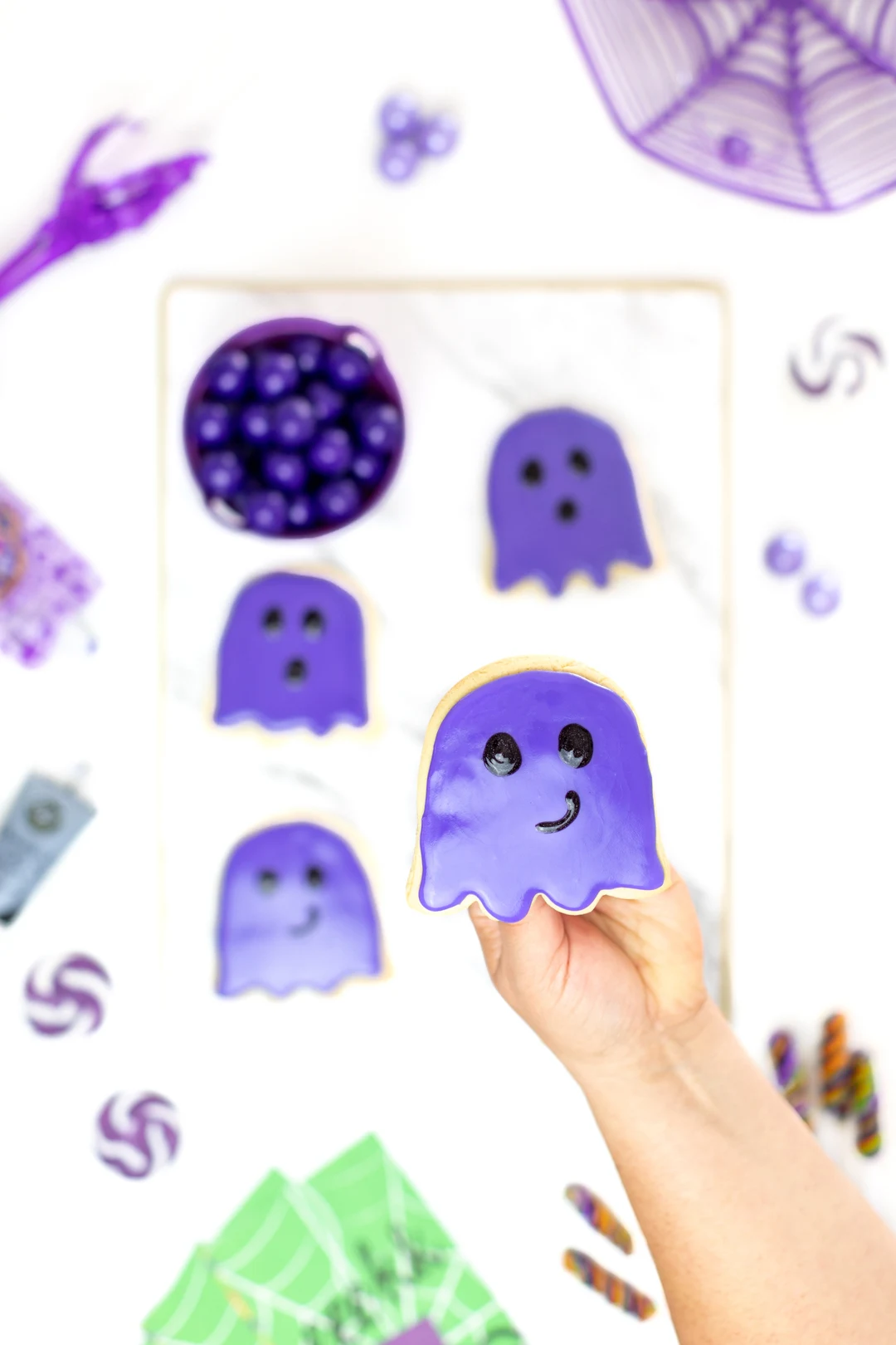 holding purple ghost cookie