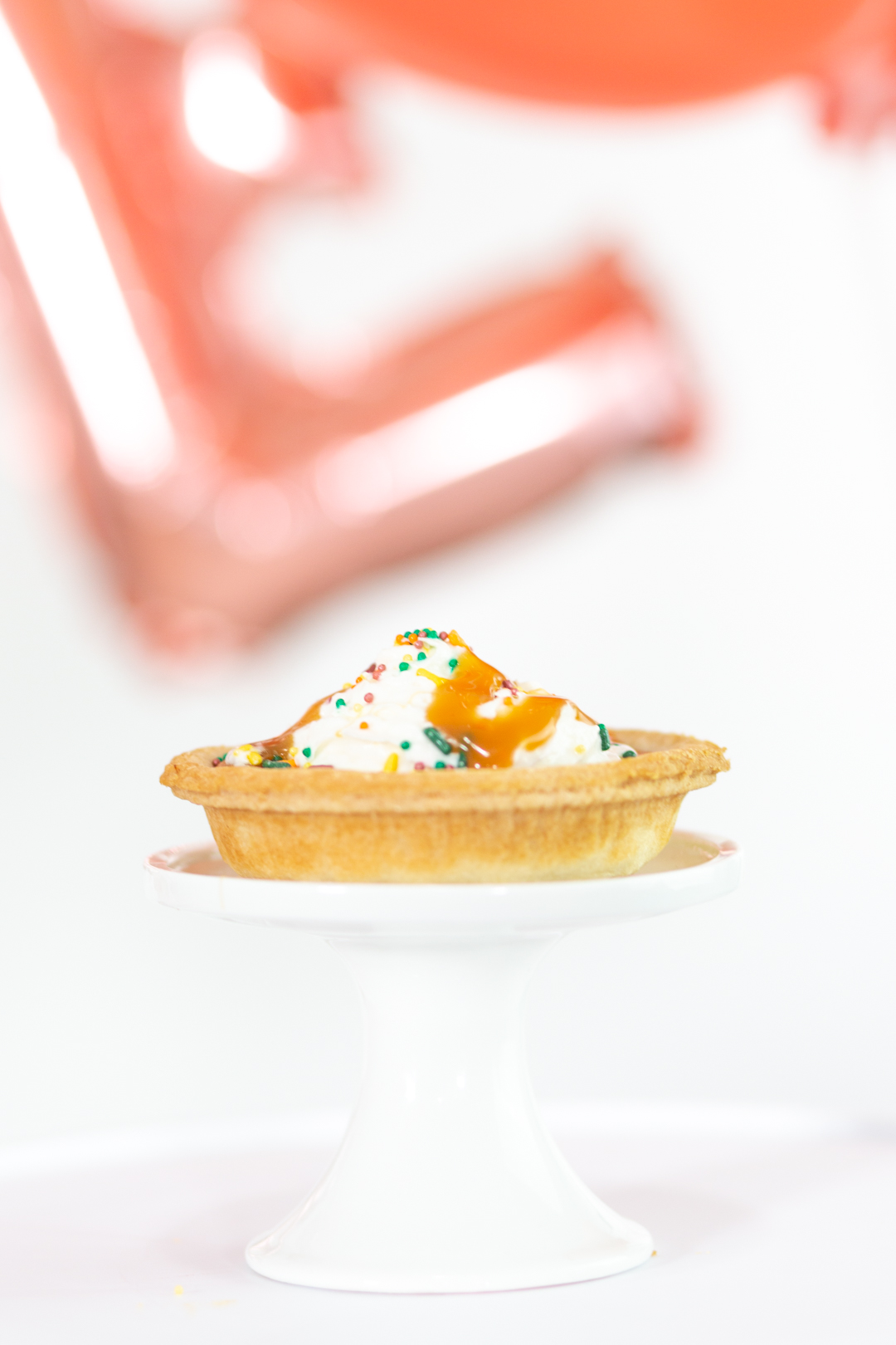 mini pumpkin pie with whipped cream, caramel and fall sprinkles