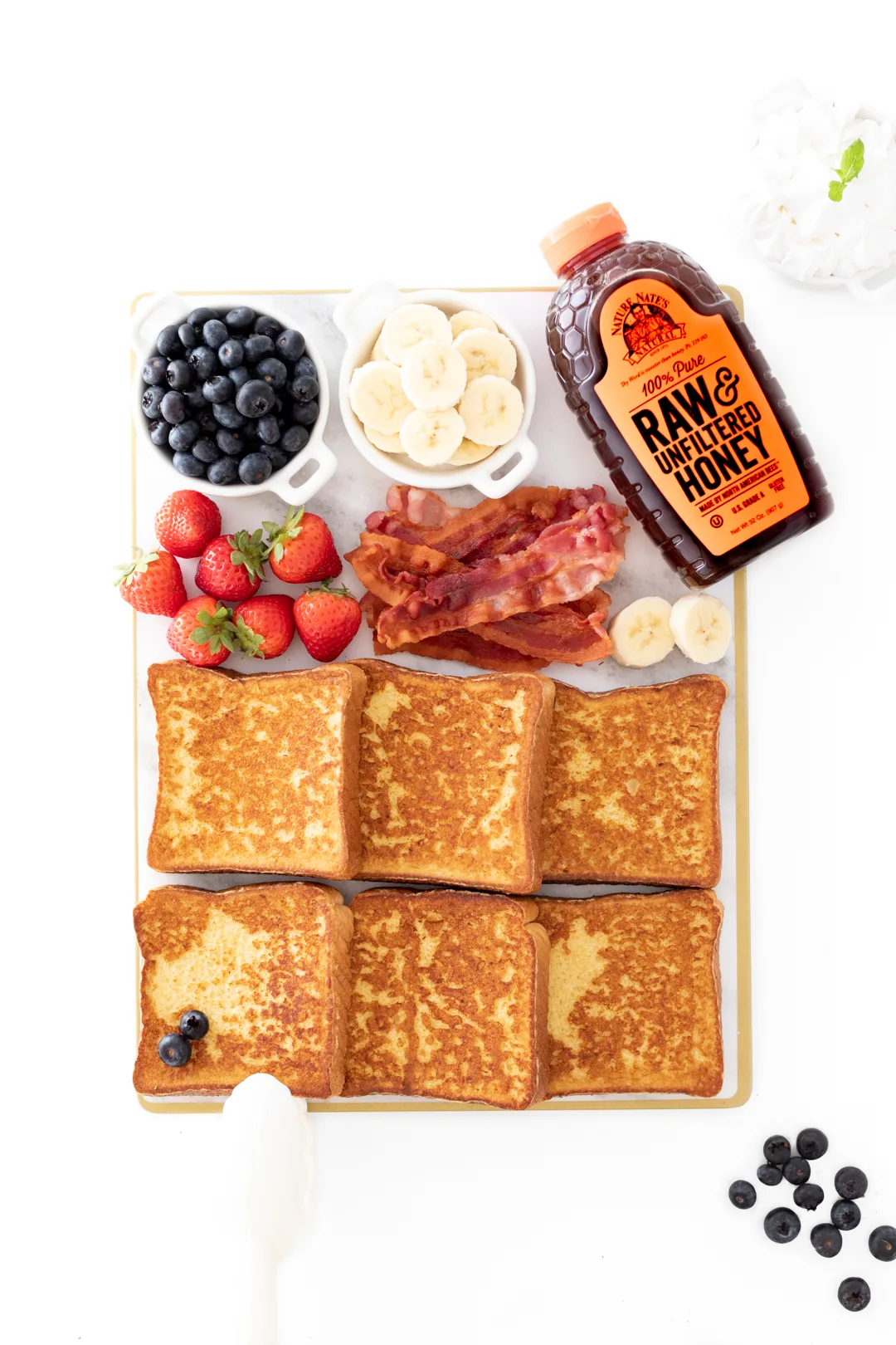tray of french toast with fresh fruit and honey