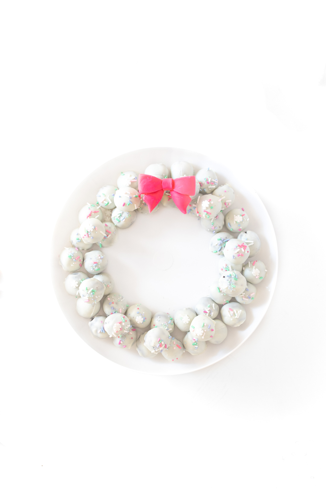 pretty OREO cookie wreath made with white OREO cookie balls and a fondant pink bow.