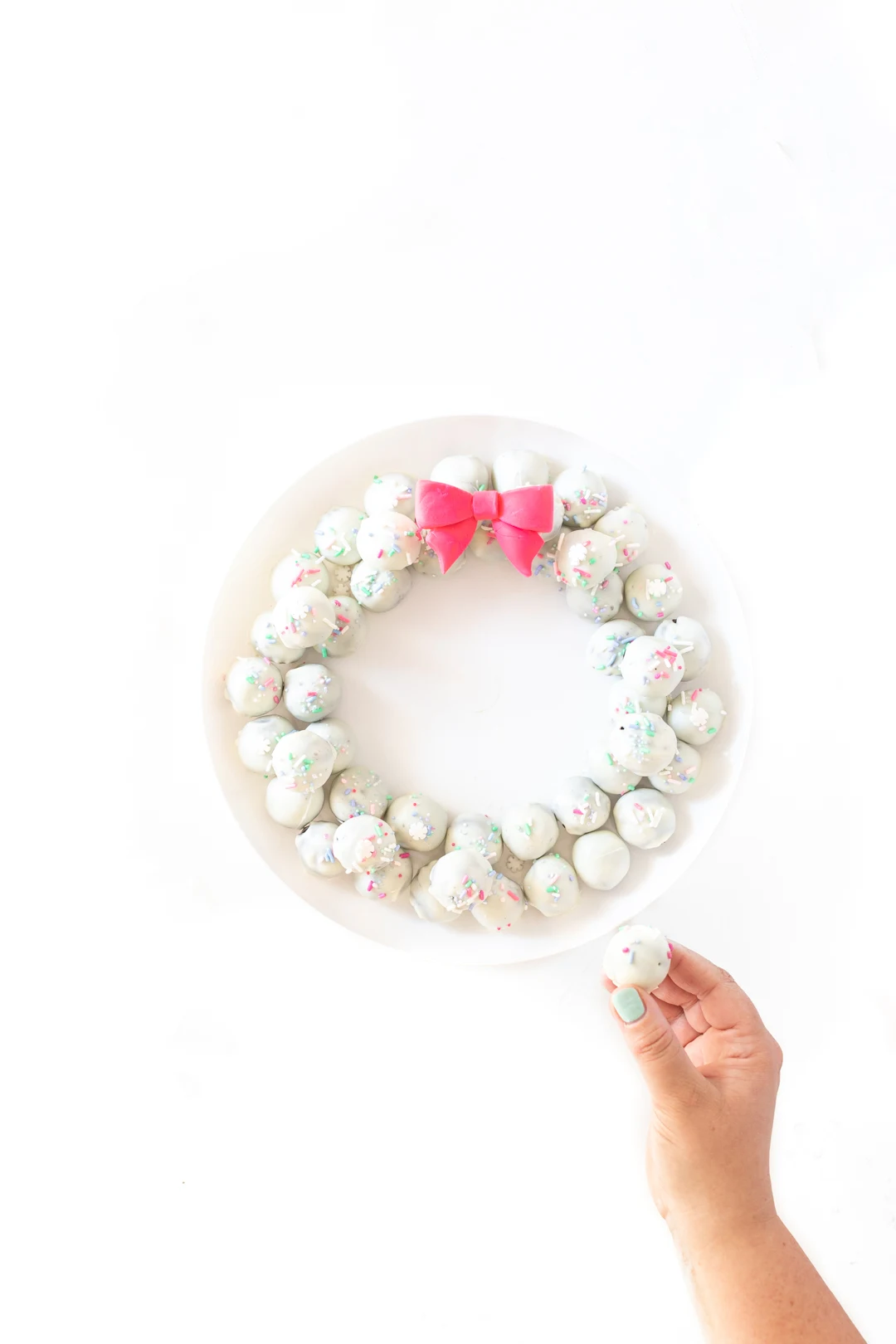 pretty OREO cookie wreath made with white OREO cookie balls and a fondant pink bow.