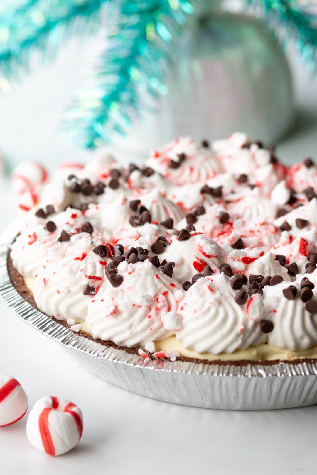 gorgeous pie topped with whipped cream, crushed peppermint and mini chocolate chips